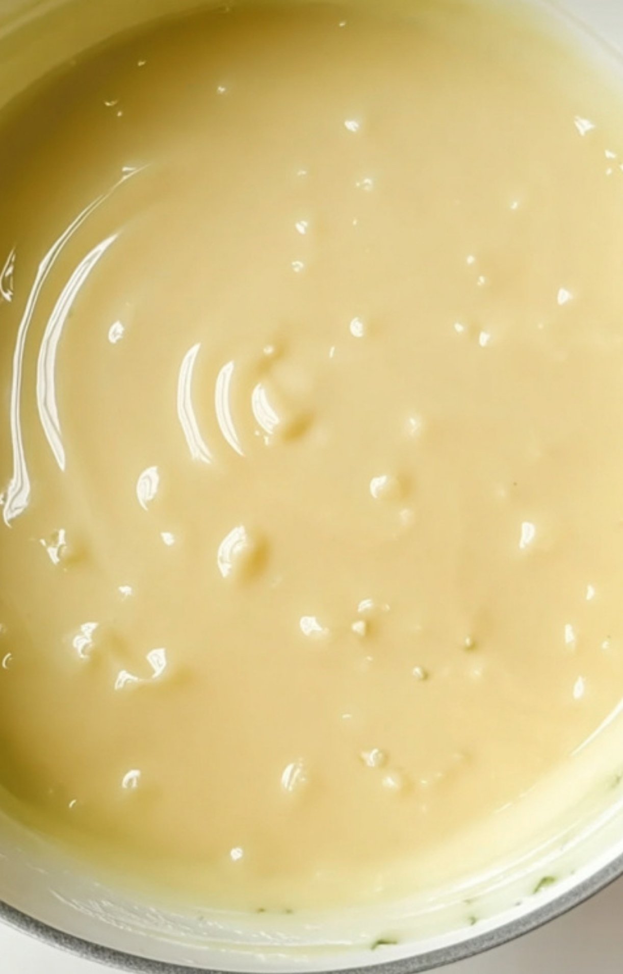 Smooth and creamy golden gravy in a skillet, freshly whisked to the perfect consistency.