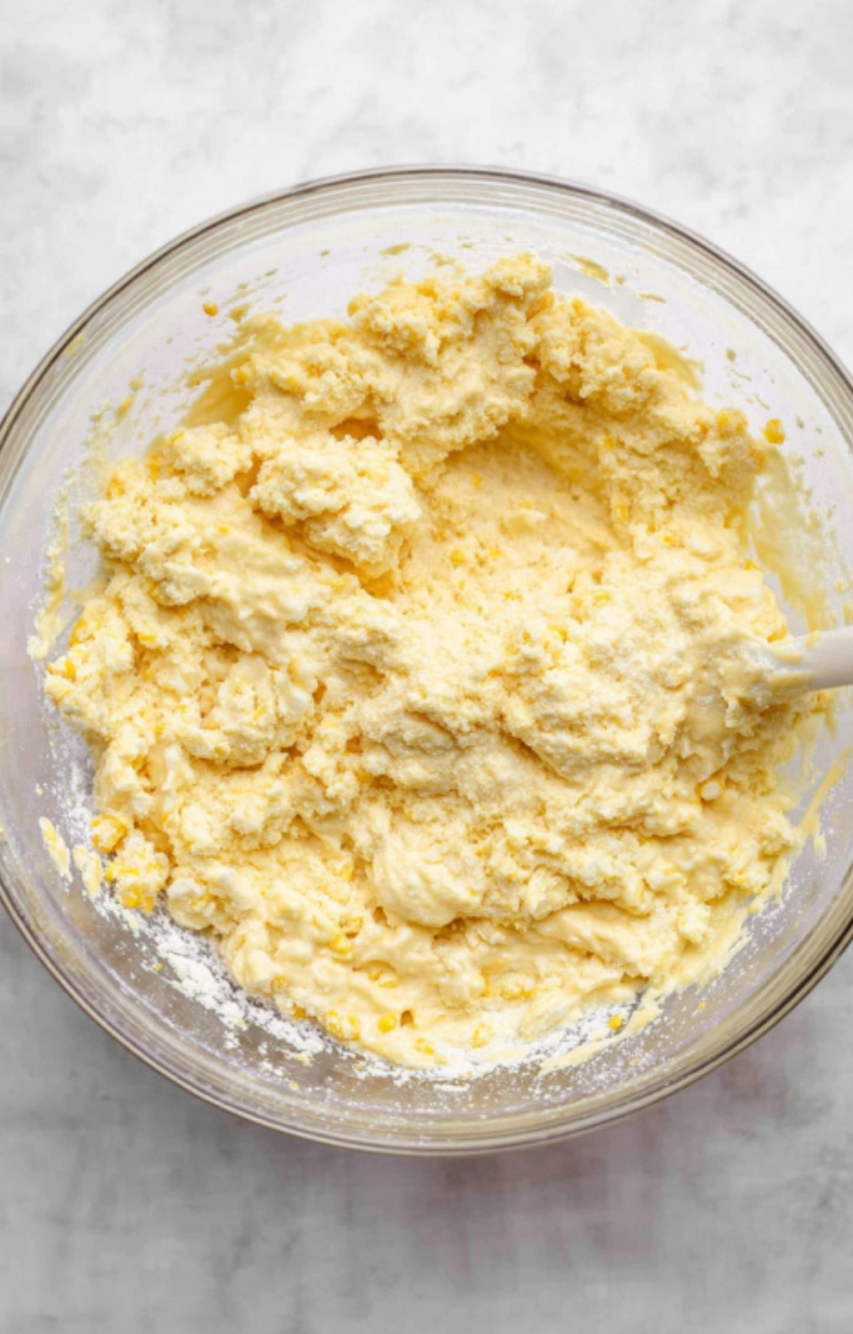 Mixing together the creamy batter for Corn Bake Casserole Jiffy with real corn and Jiffy mix in a glass bowl, perfect for Thanksgiving and family gatherings.