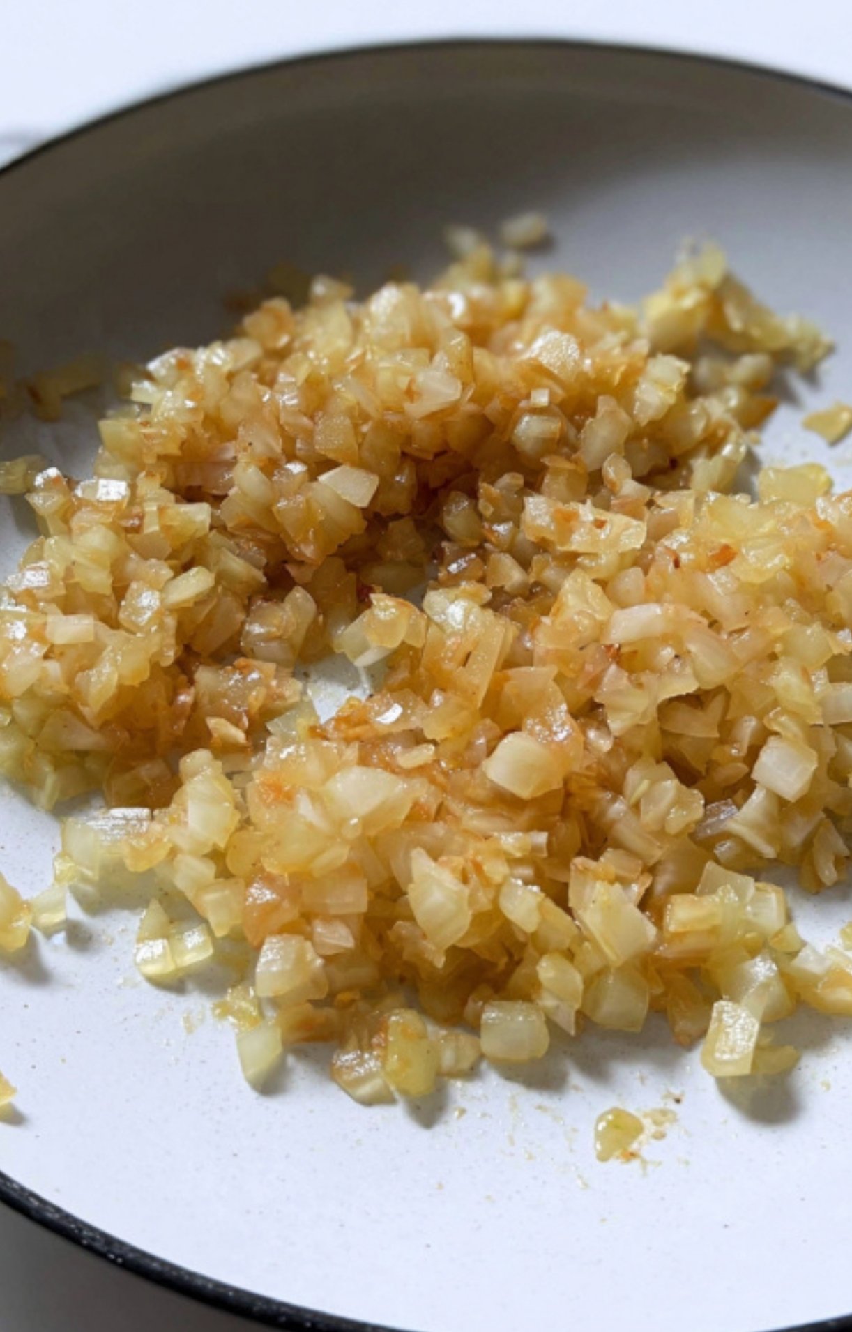 Golden caramelized onions in a pan. Adds sweetness and depth to Filipino chicken caldereta recipes.