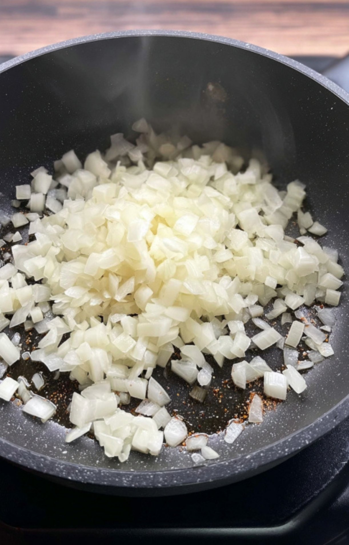 Diced onions cooking in a pan, getting soft and golden. This step adds sweetness and depth to the slow cooker beef goulash.