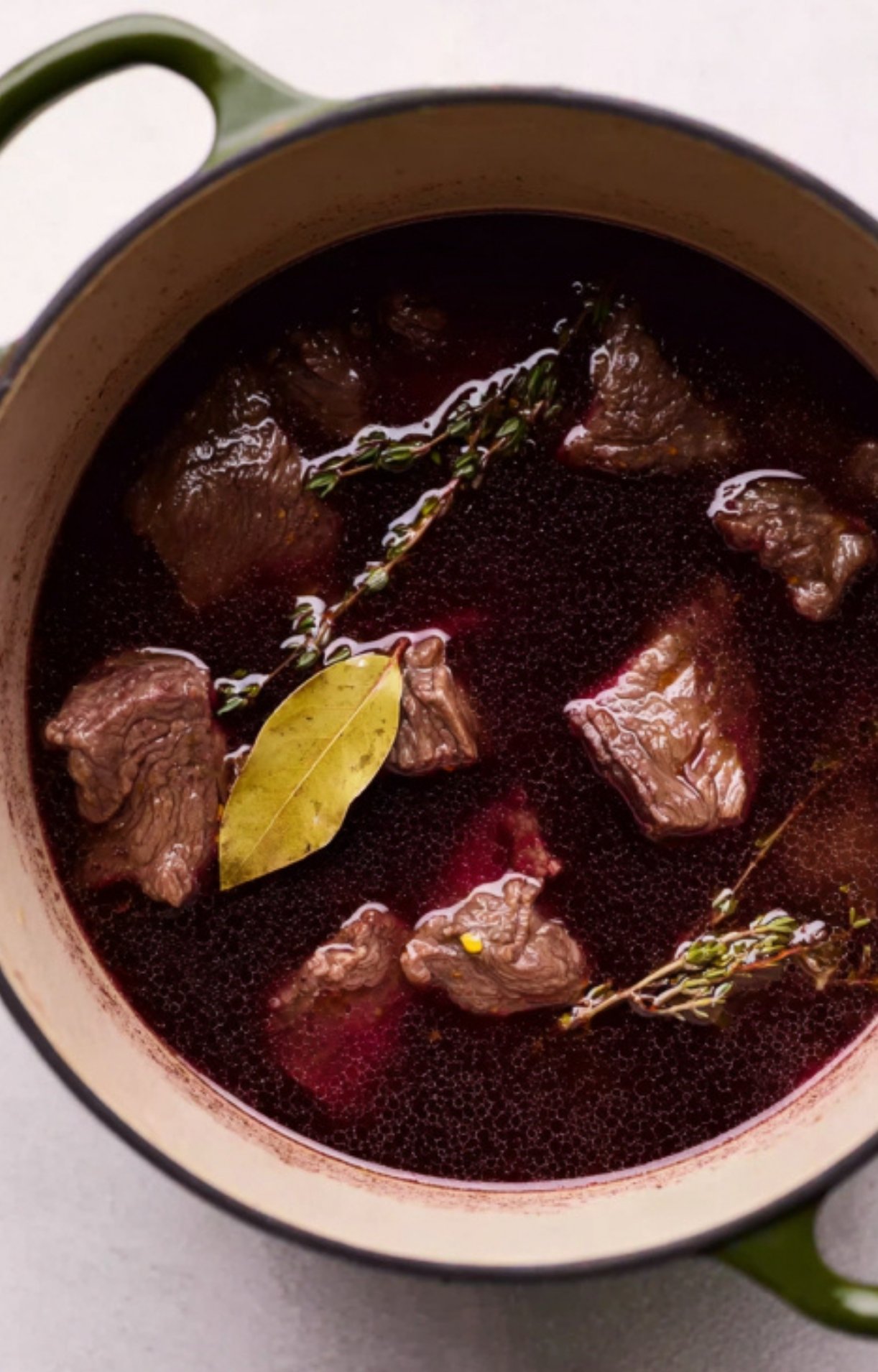 Chunks of beef marinating in red wine, bay leaf, and thyme for authentic French beef stew. A key step for tender, flavorful results.