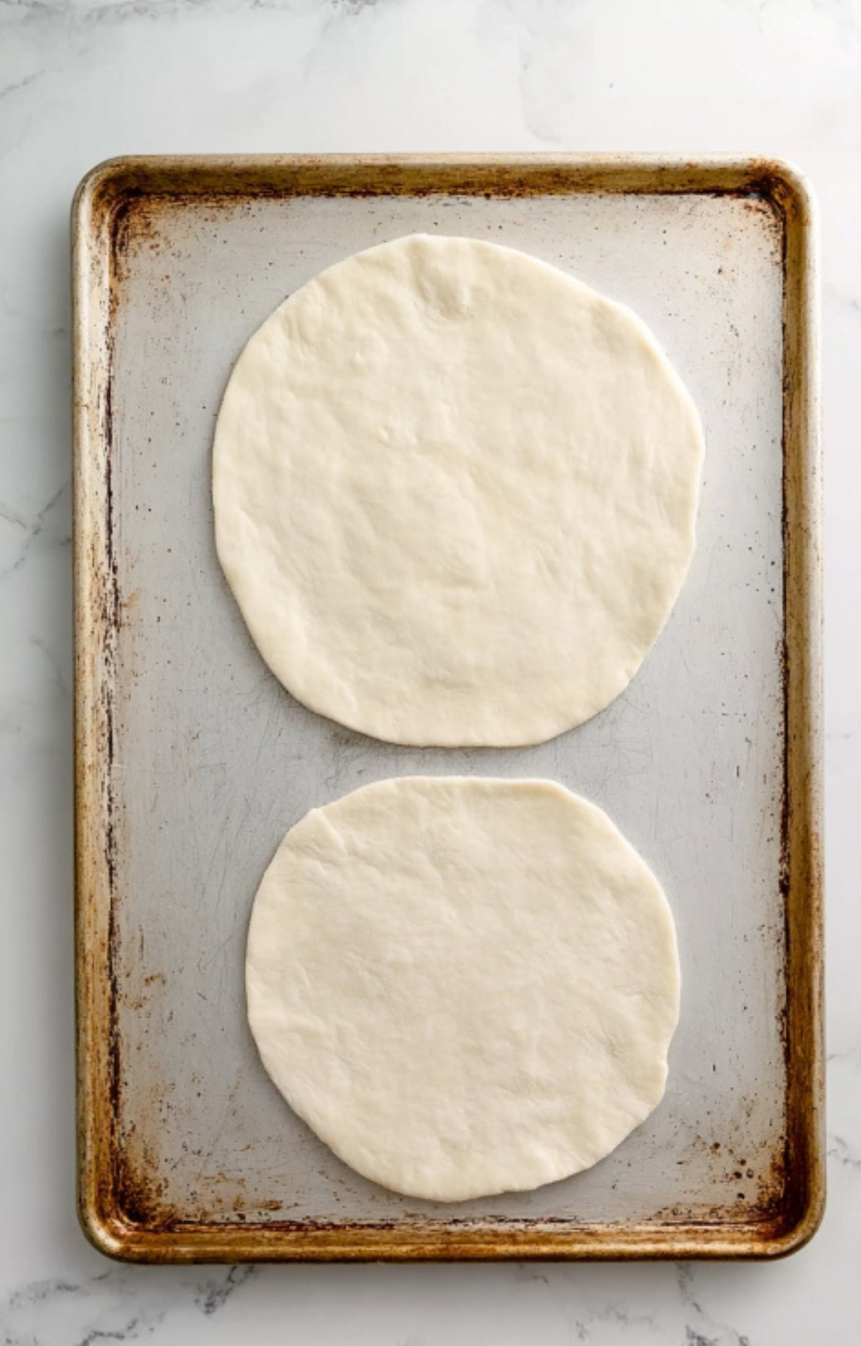 Two rounds of puff pastry dough on a baking sheet, ready to wrap up juicy beef. This step is key for getting a golden, flaky crust on your classic Beef Wellington.