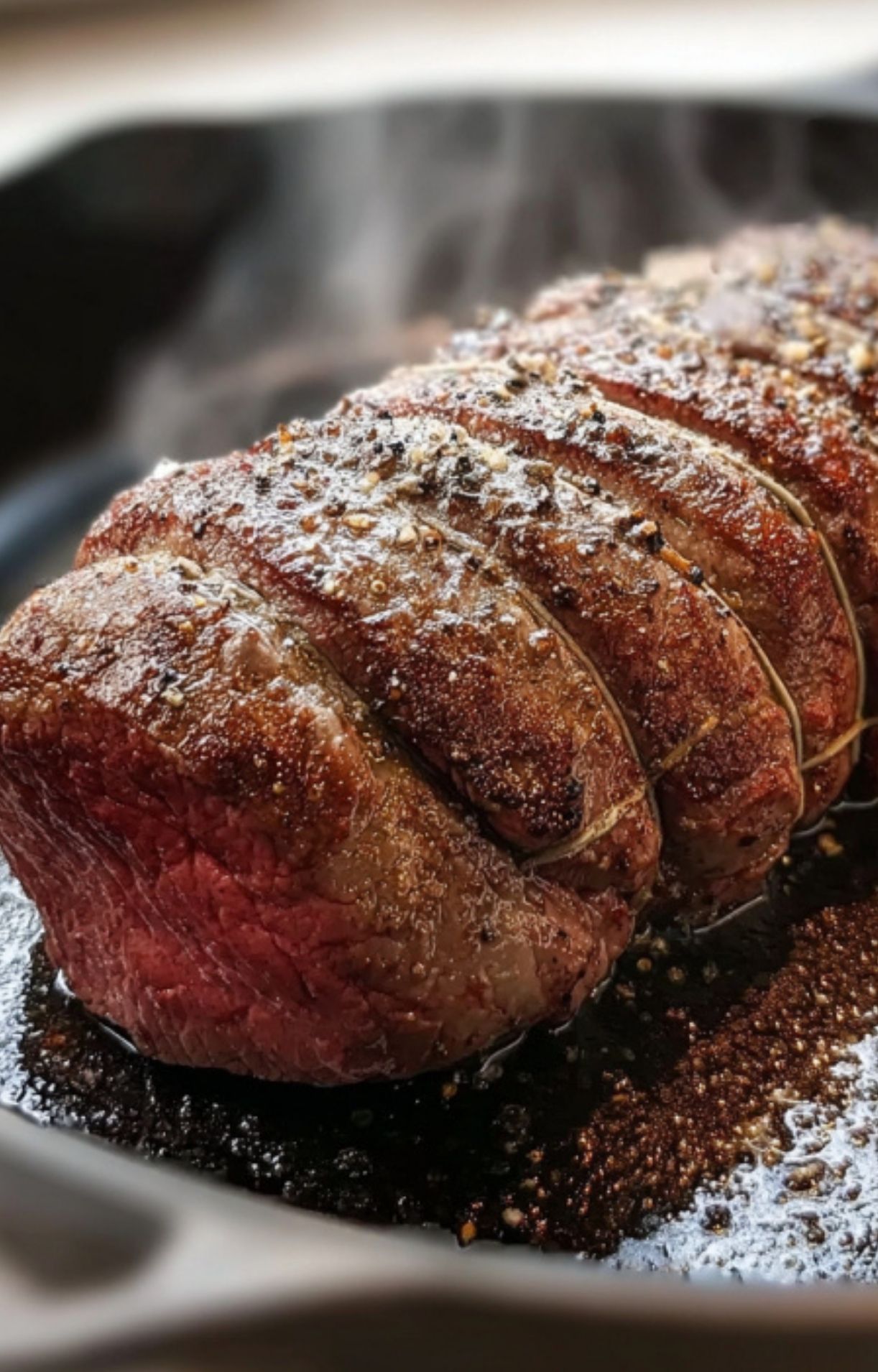 Seasoned beef tenderloin being seared in a hot skillet, the first step for preparing a gluten free beef wellington recipe.