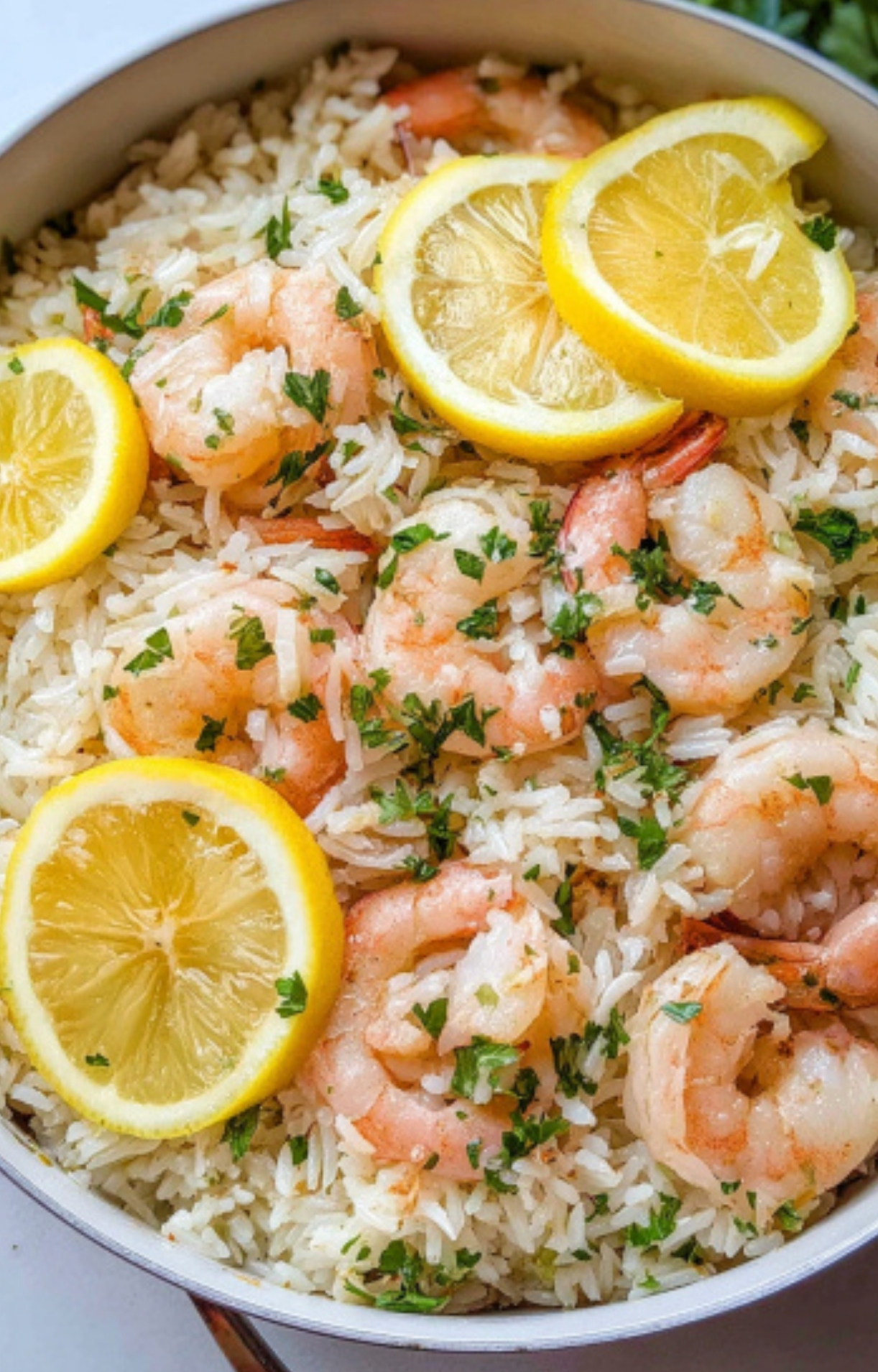 Close-up of lemon garlic shrimp and rice in a skillet, topped with fresh lemon, ideal cheap dinner for a family