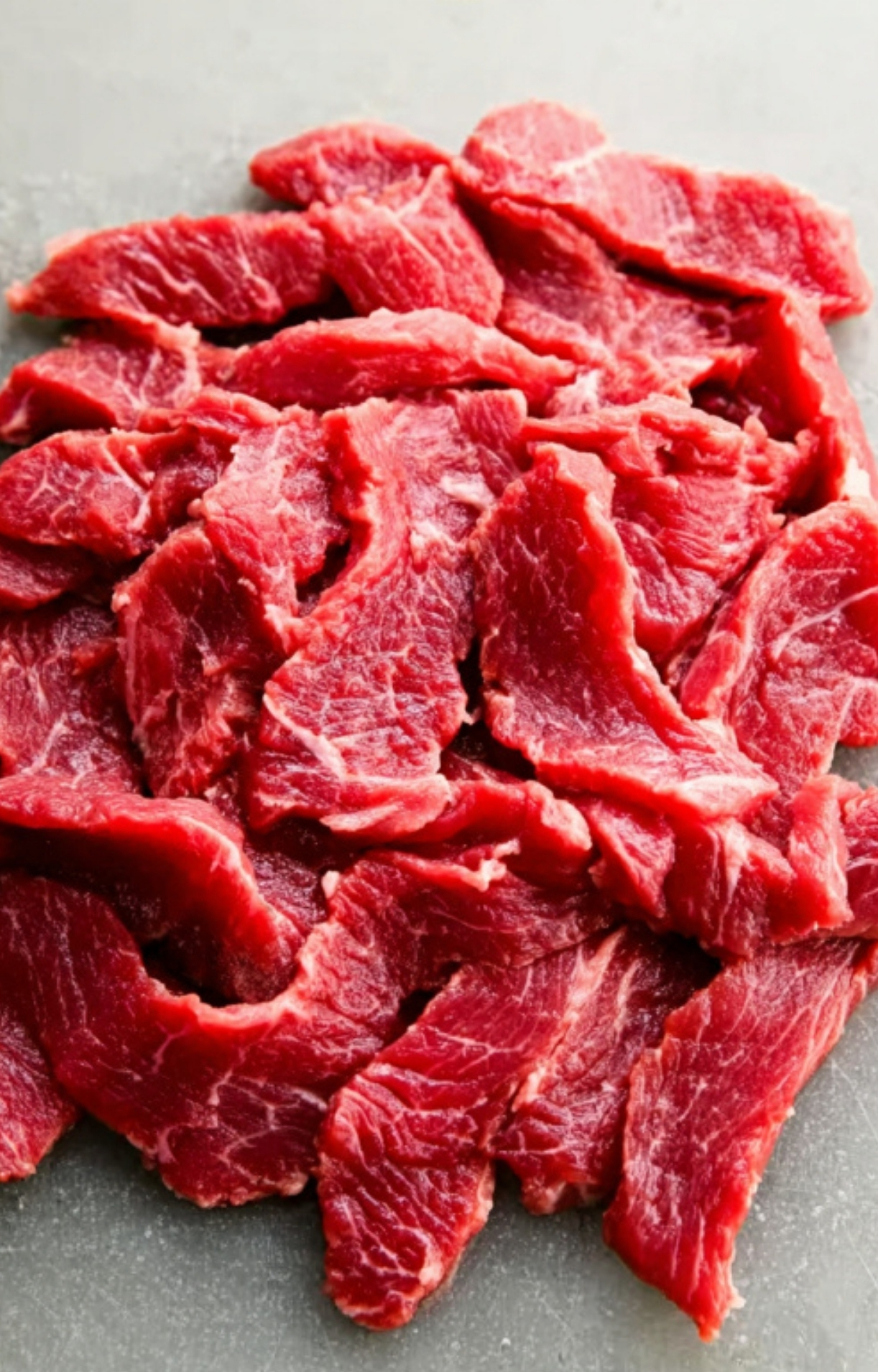 Raw top sirloin beef strips ready for a fast and flavorful pepper steak recipe.