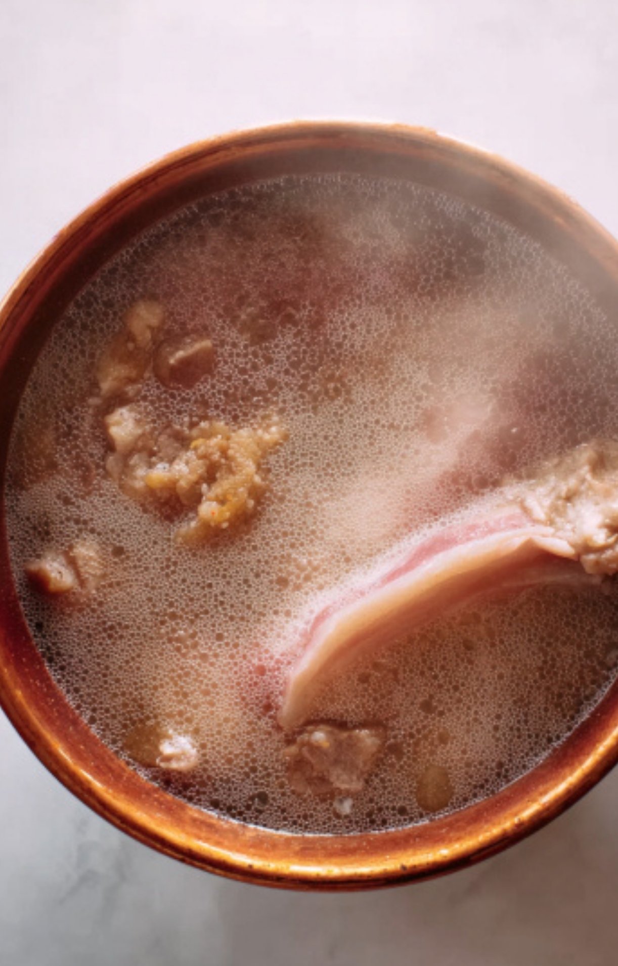 Pancetta simmering in water to add rich, savory flavor to a classic French beef stew. Perfect for bistro-style meals.