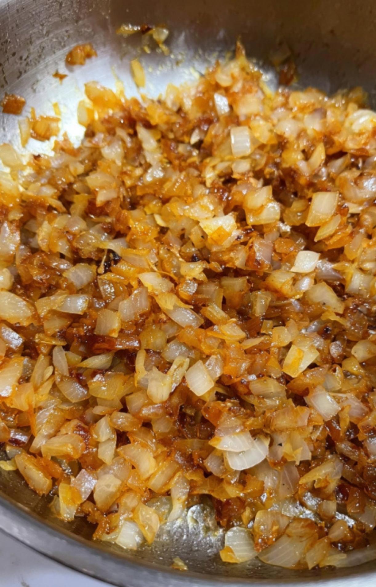 Golden-brown onions in a pan, a key step for building the classic taste of German beef goulash. Perfect for easy comfort food and winter stew recipes.