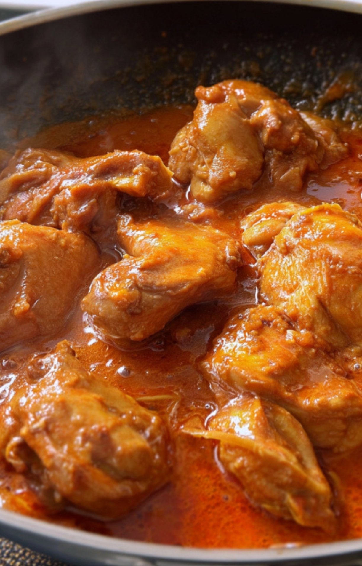 Close-up of chicken pieces simmering in thick caldereta sauce. Great for cozy family dinners and comfort food cravings.