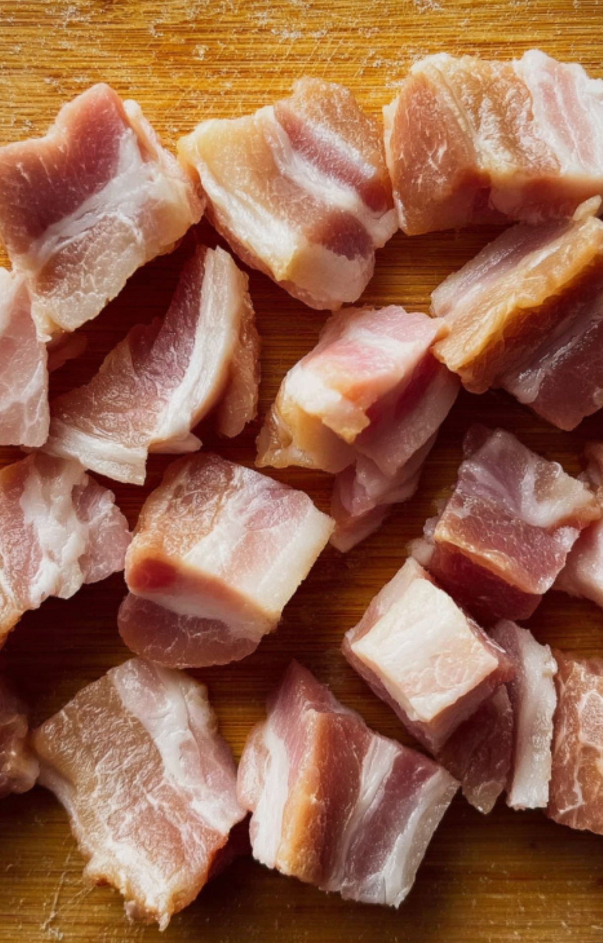 Diced pancetta on a wooden cutting board, ready for French beef stew. Essential step for building flavor in traditional French comfort food.