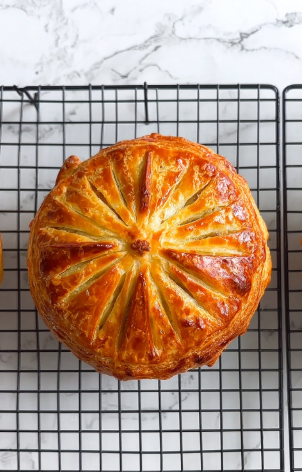 Close-up of Beef Wellington cut in half, showing layers of flaky pastry, cheddar cheese, and tender beef. Perfect recipe for festive meals and family gatherings.