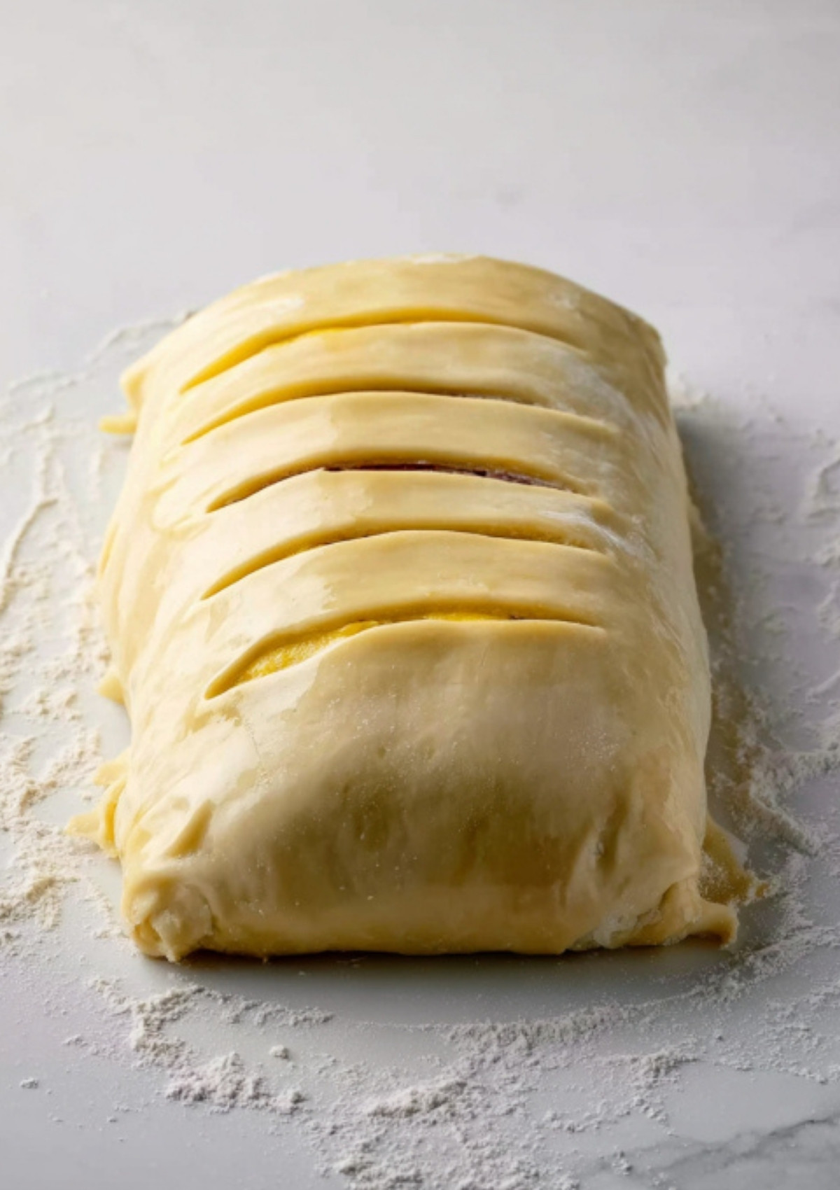 Unbaked gluten free beef wellington wrapped in homemade pastry, scored and ready to bake for a festive, dairy free main course.