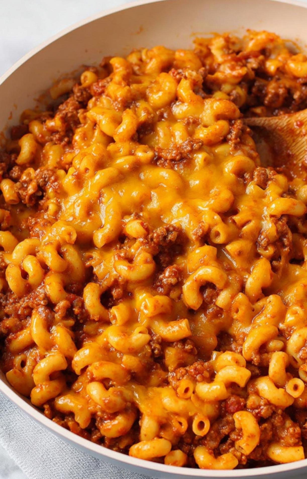 Large pot filled with cheesy goulash made from ground beef, elbow macaroni, and melted cheddar cheese. Perfect for easy weeknight dinners and cozy family meals.
