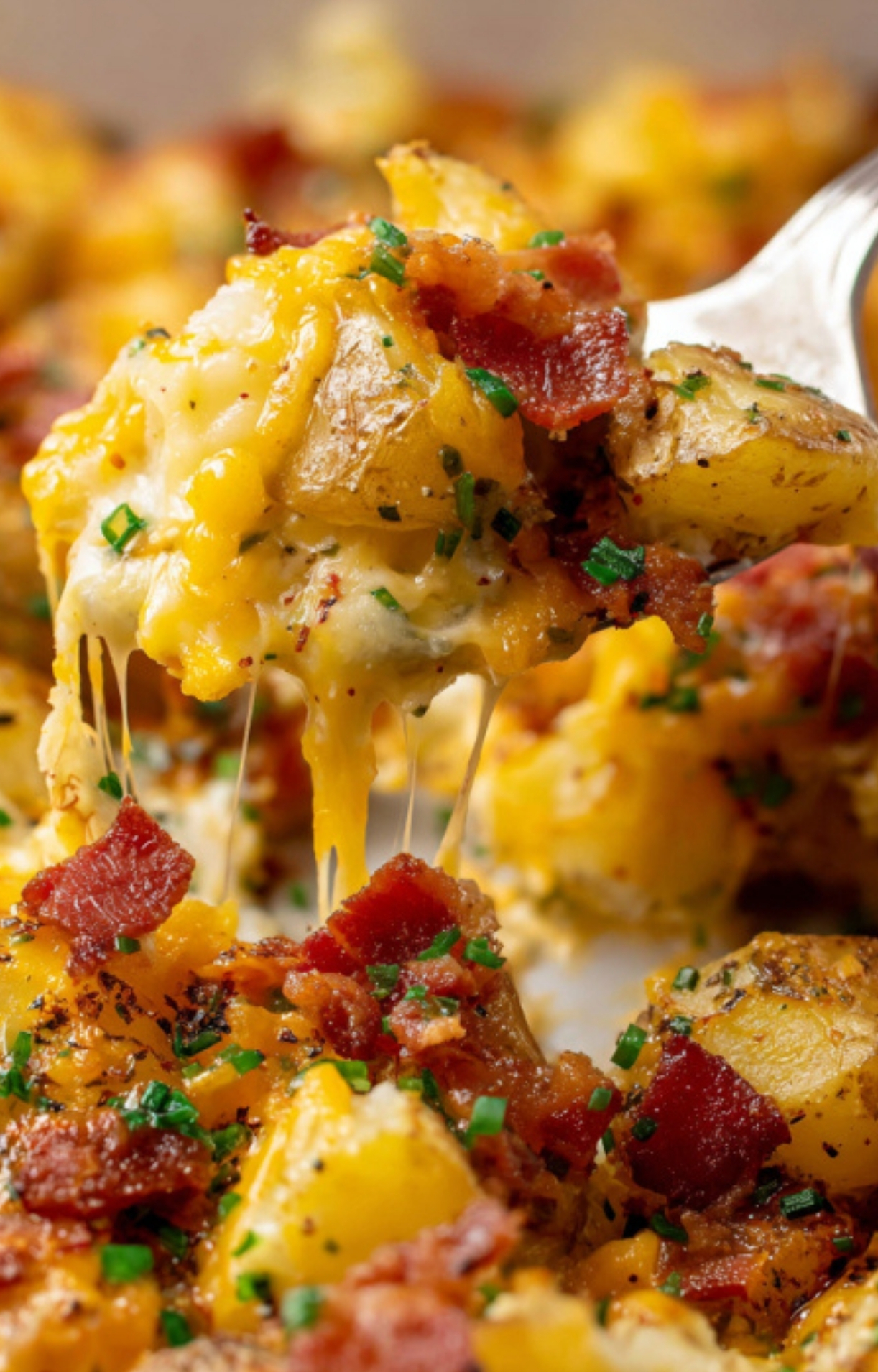 Closeup of cheesy bacon ranch potatoes with crispy bacon, melted cheddar, and fresh chives for the best loaded potato casserole.