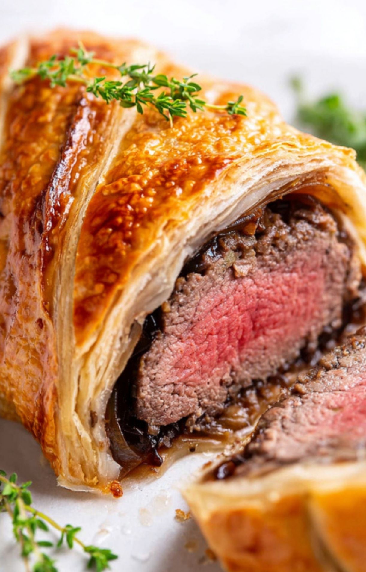 Golden slice of beef wellington without mushrooms, filled with tender beef and savory onions in flaky pastry, ideal for Christmas dinner or elegant parties