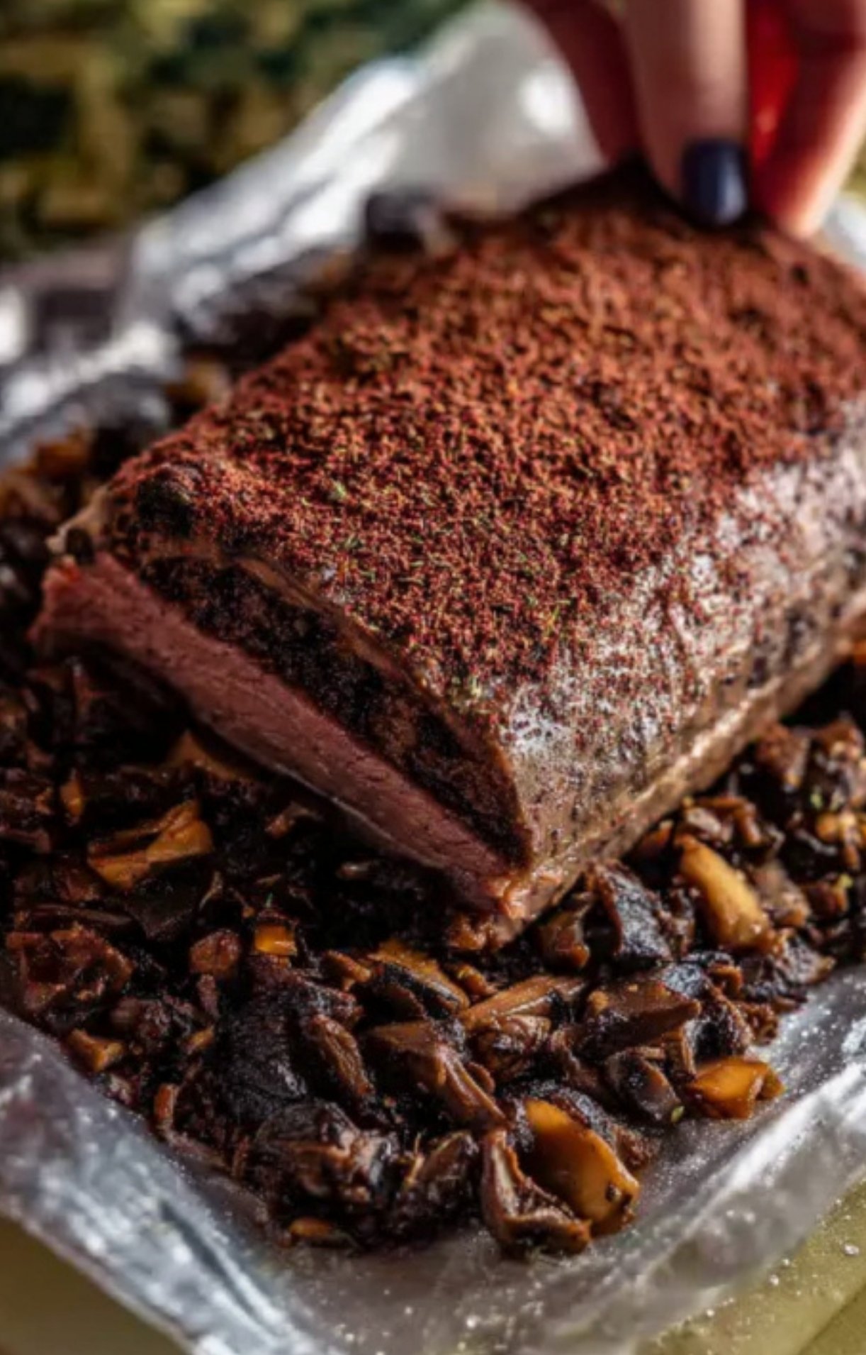 Red wine sauce poured over sliced smoked beef wellington