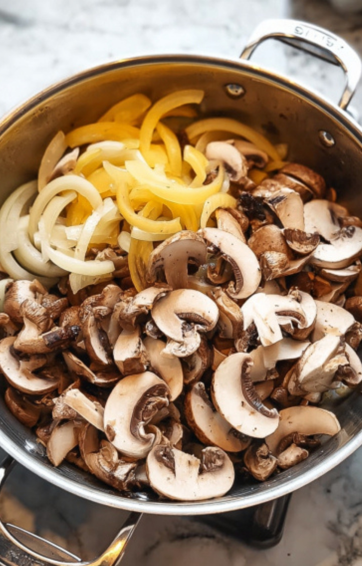 Freshly sliced yellow onions and mushrooms in a skillet, ready for cooking Salsberry Steak With Mushroom Gravy—a cozy, homemade comfort food classic.