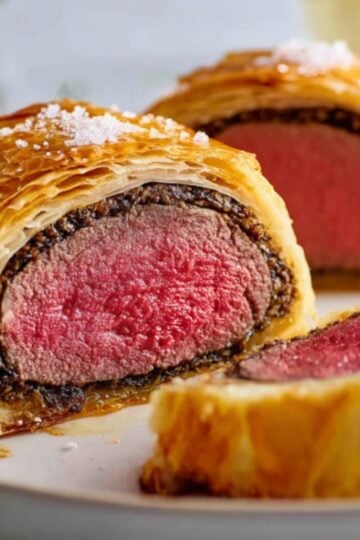 Thick slices of beef Wellington wrapped in crisp, golden puff pastry and savory mushrooms, perfect for Christmas dinner, holiday gatherings, and special celebrations.