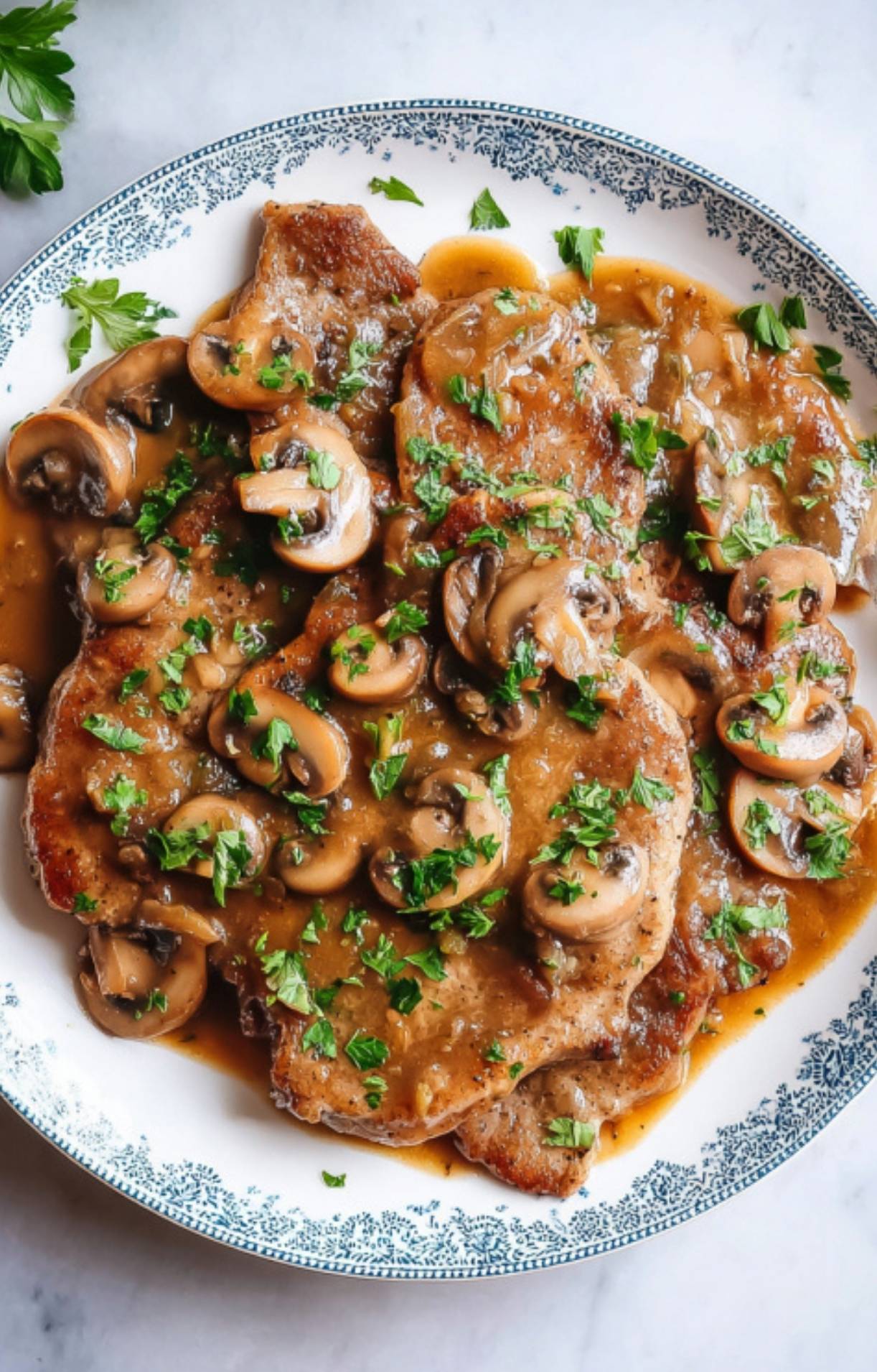 Plate of marsala veal scallopini topped with mushrooms and parsley, perfect for an easy Italian dinner or special family meal