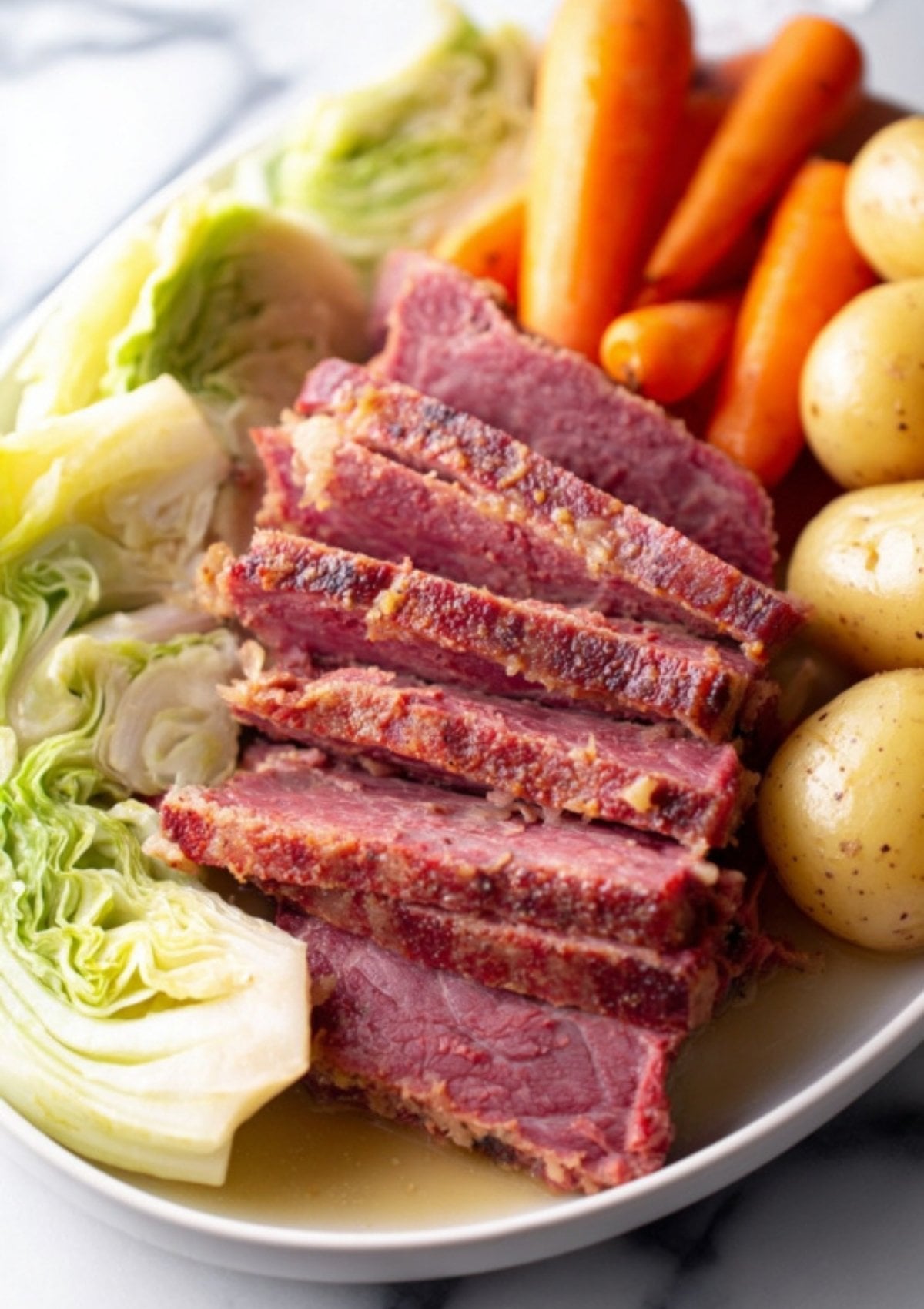 Juicy sliced corned beef with carrots, cabbage, and potatoes on a serving platter. Fast and easy Instant Pot meal perfect for St. Patrick’s Day, weeknight dinners, and hearty family meals.