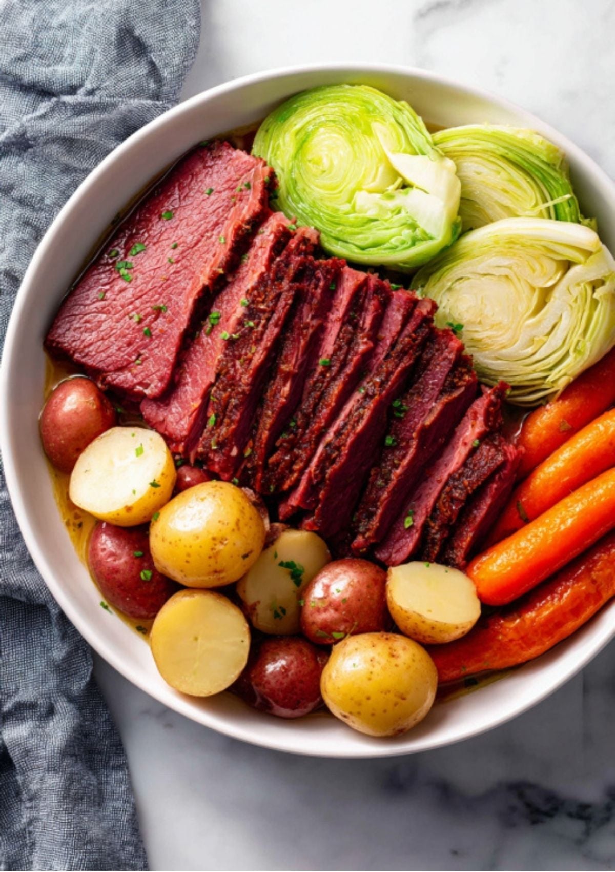 Bowl filled with thick slices of corned beef, new potatoes, carrots, and rolled cabbage—perfect comfort food for St. Patrick’s Day.