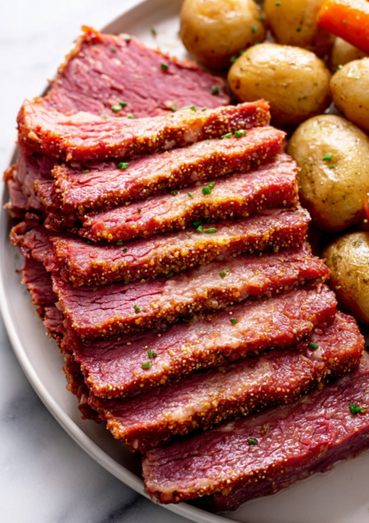 Stack of sliced corned beef served with tender potatoes on a plate. Easy crockpot meal for busy families, holiday gatherings, or classic comfort food cravings.
