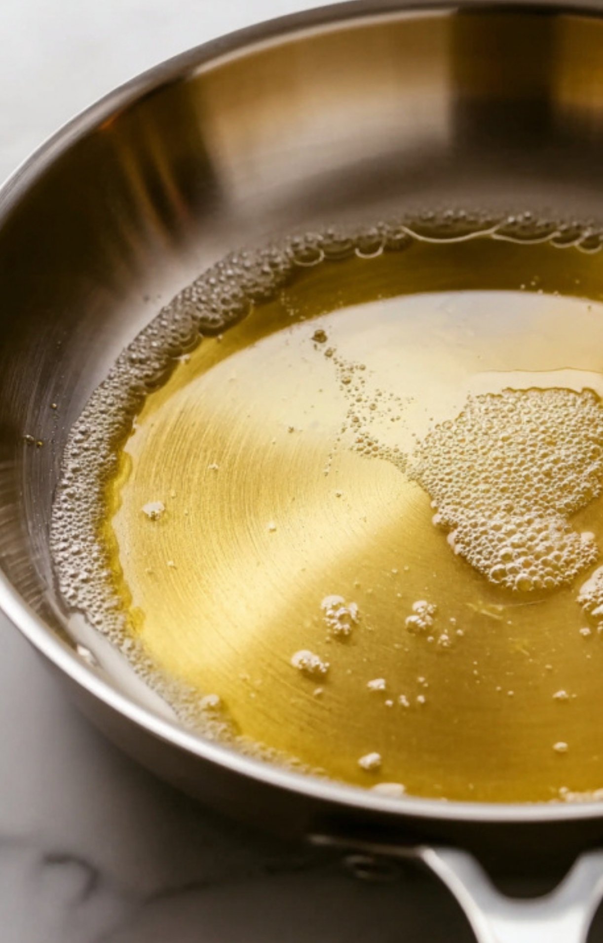 Veal cutlets frying in a skillet with butter, bubbling as they cook. Learn the best way to get that golden sear and juicy flavor at home.