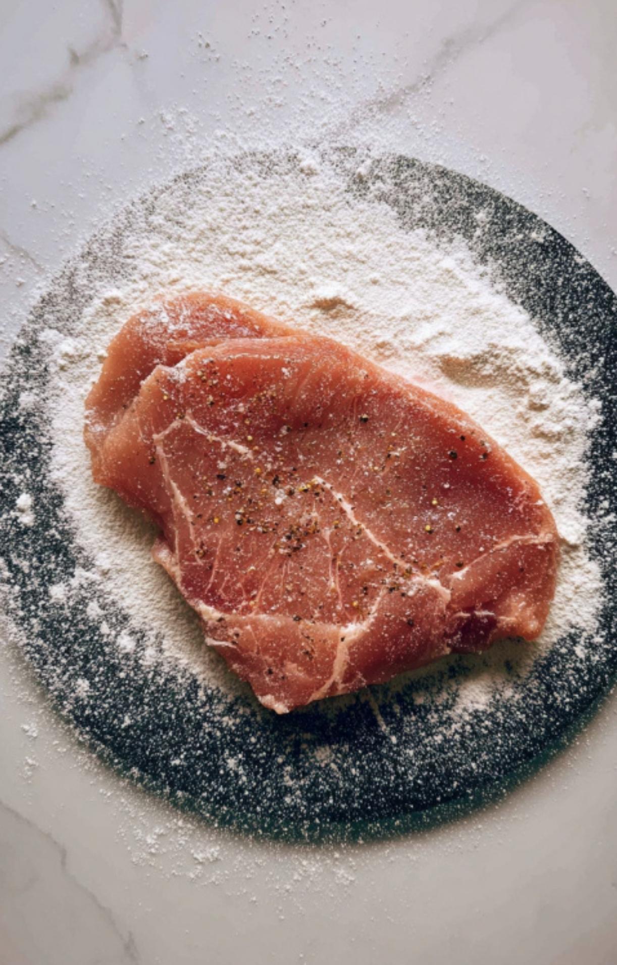 Three veal cutlets sizzling in a skillet, developing a golden-brown crust. Key to making the best veal piccata in white wine sauce for a quick weeknight dinner.