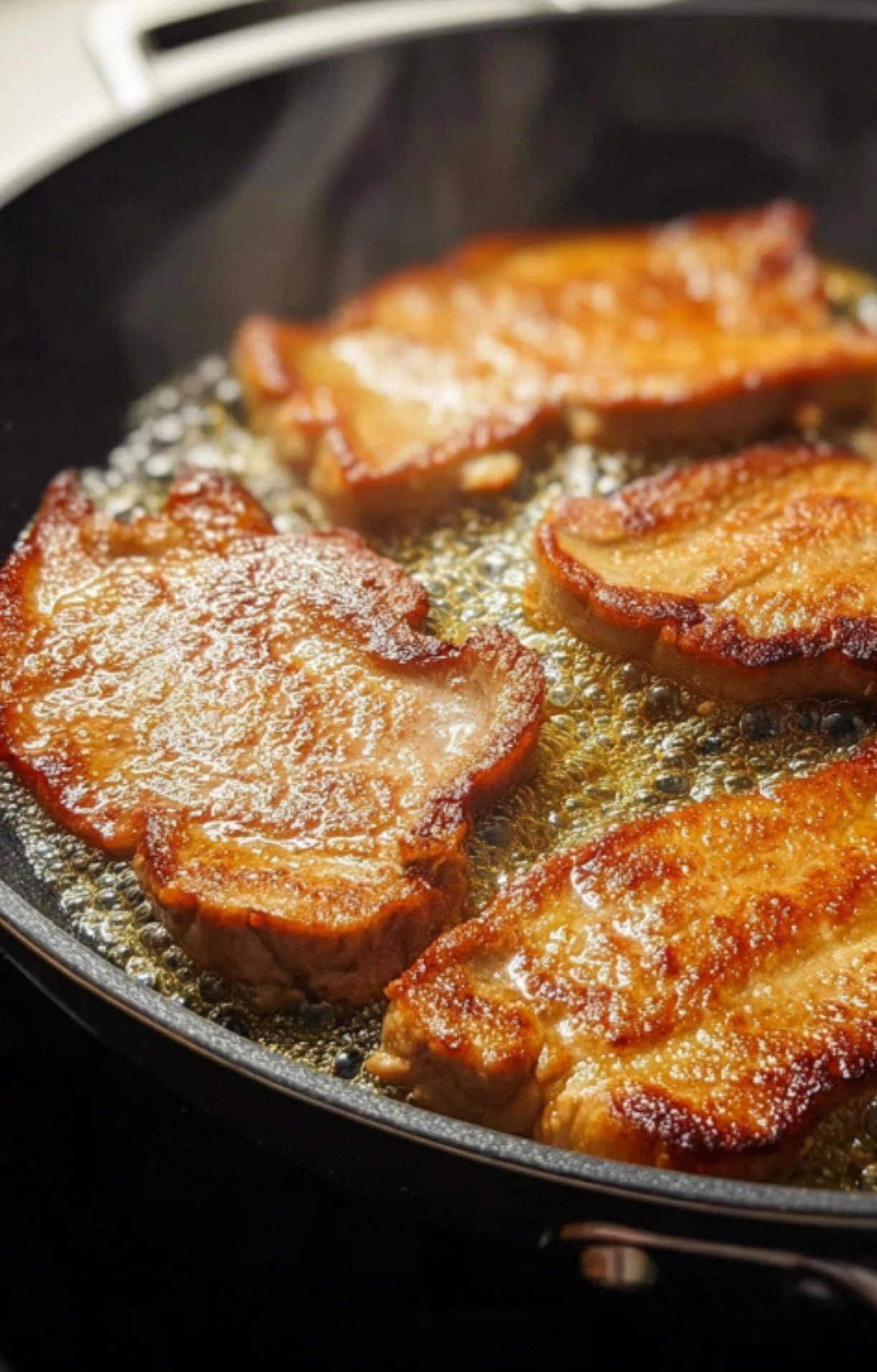 Golden veal cutlets frying in a skillet, the first step for delicious Italian veal scallopini