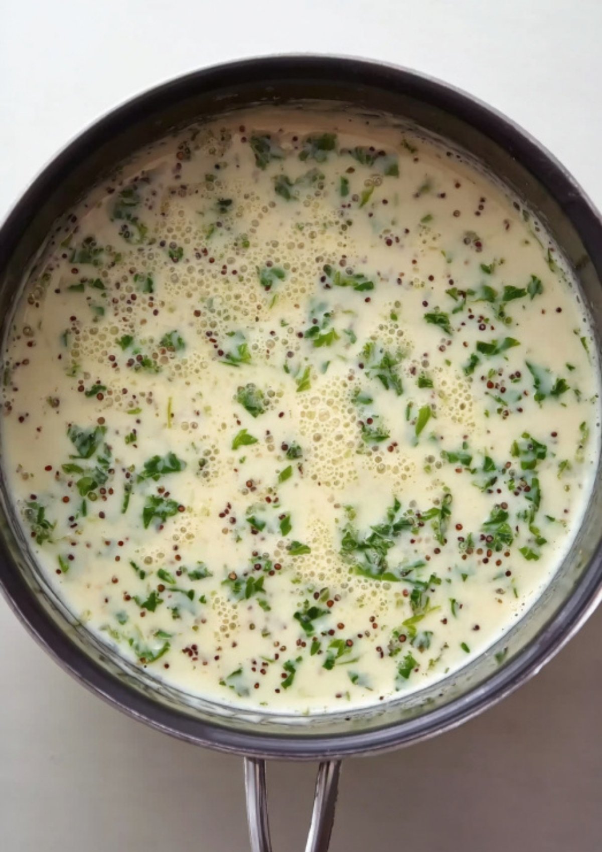 Saucepan filled with creamy parsley and wholegrain mustard sauce, perfect for serving over classic corned beef.