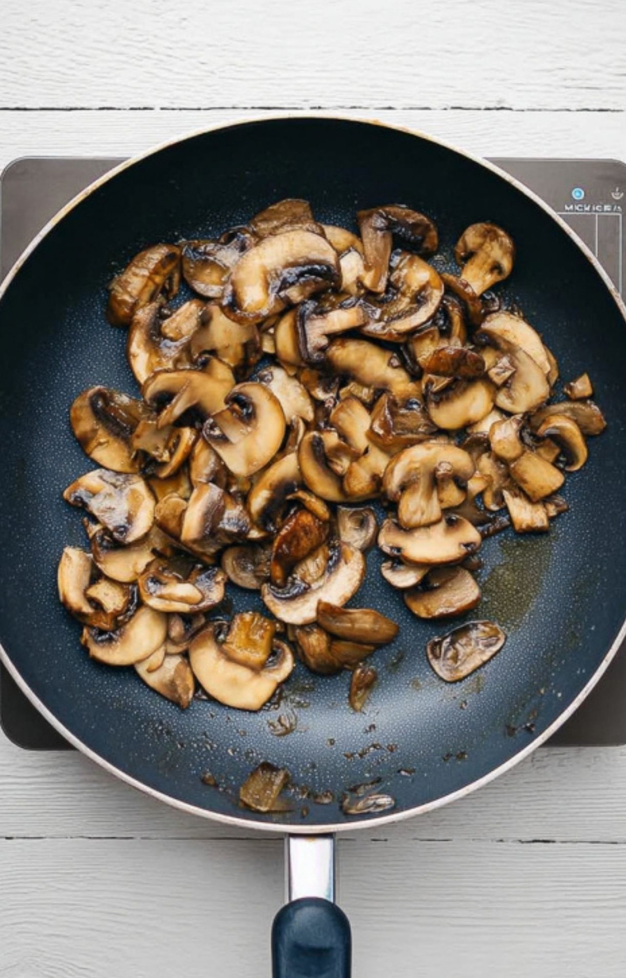 Sliced mushrooms sautéed in a nonstick skillet, golden and ready to top Italian veal scallopini.