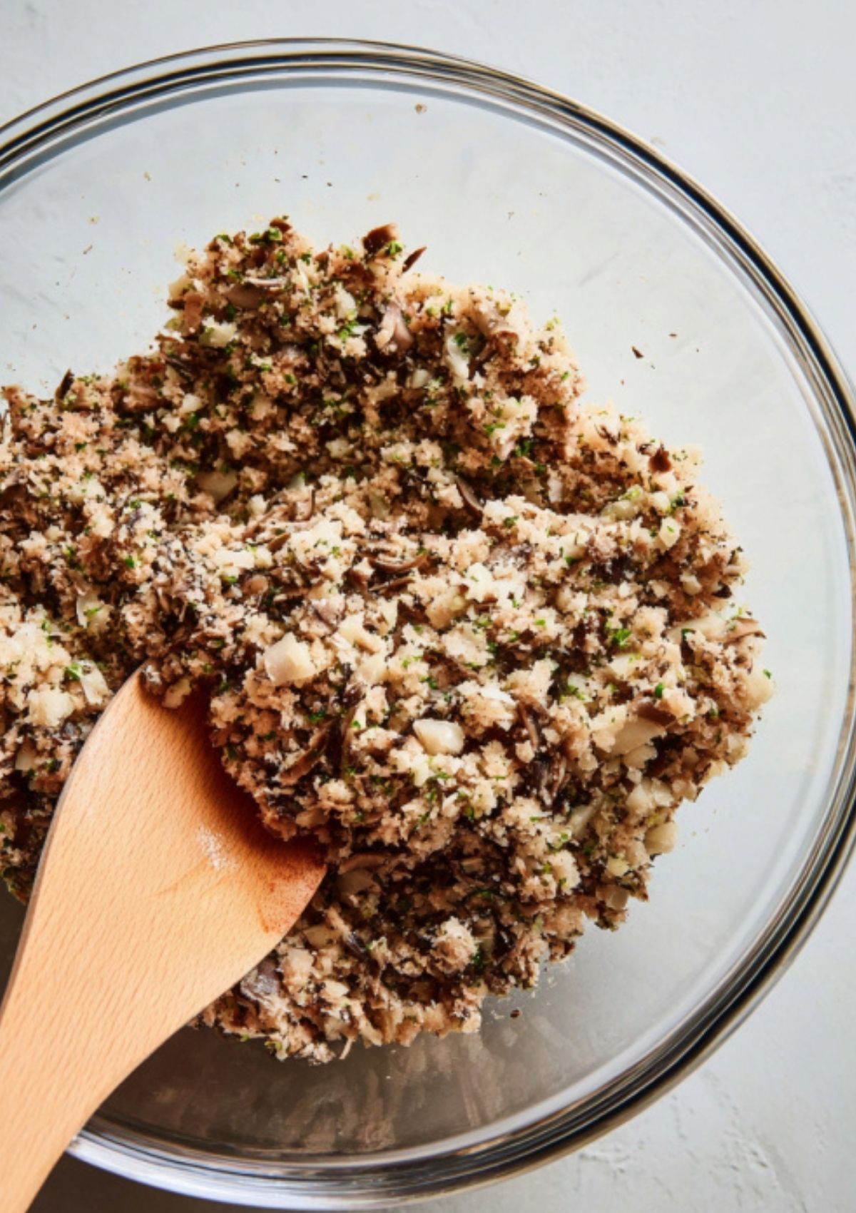 Finely chopped mushroom and herb mixture in a glass bowl, ready to layer for the ultimate beef Wellington puff pastry recipe, great for holiday dinners and entertaining.