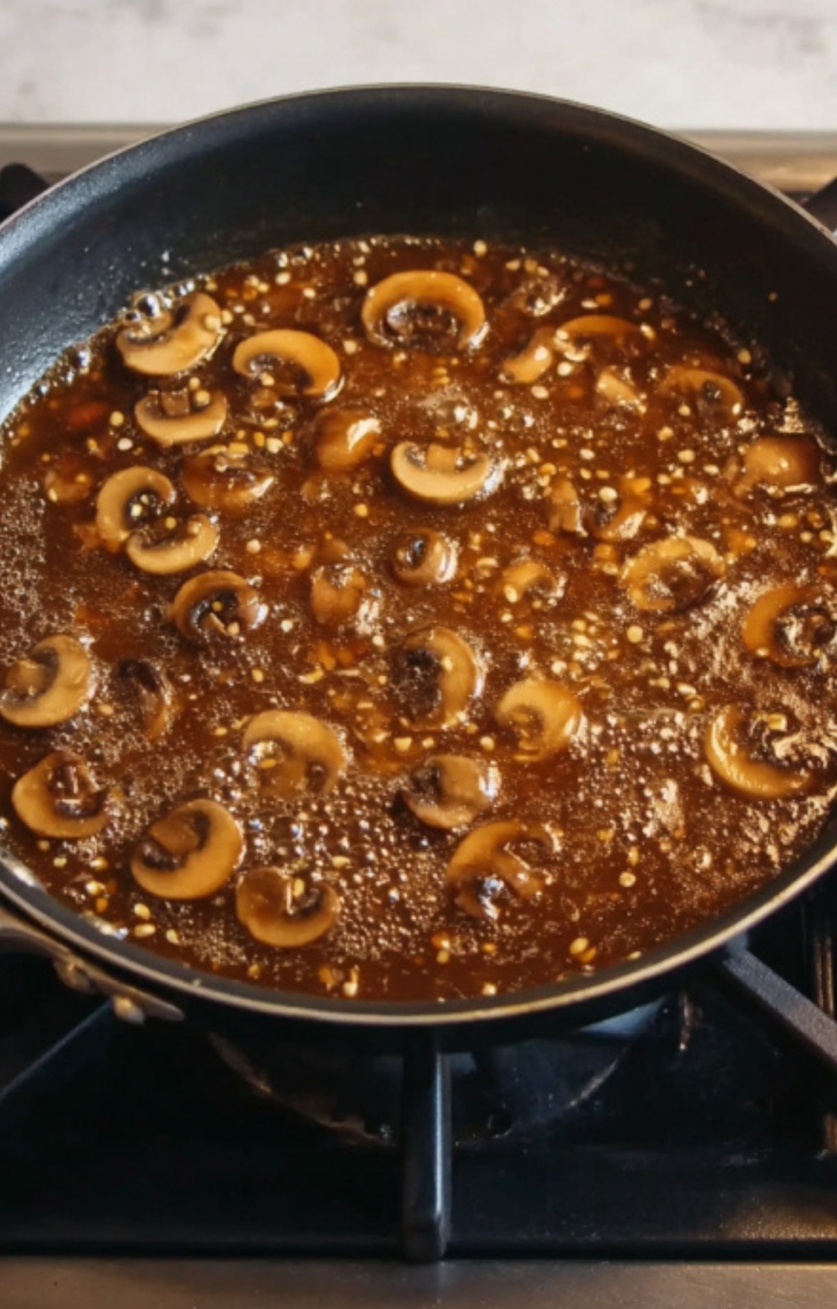 Mushrooms cooking in marsala wine sauce in a skillet, perfect for classic veal scallopini and cozy fall dinners