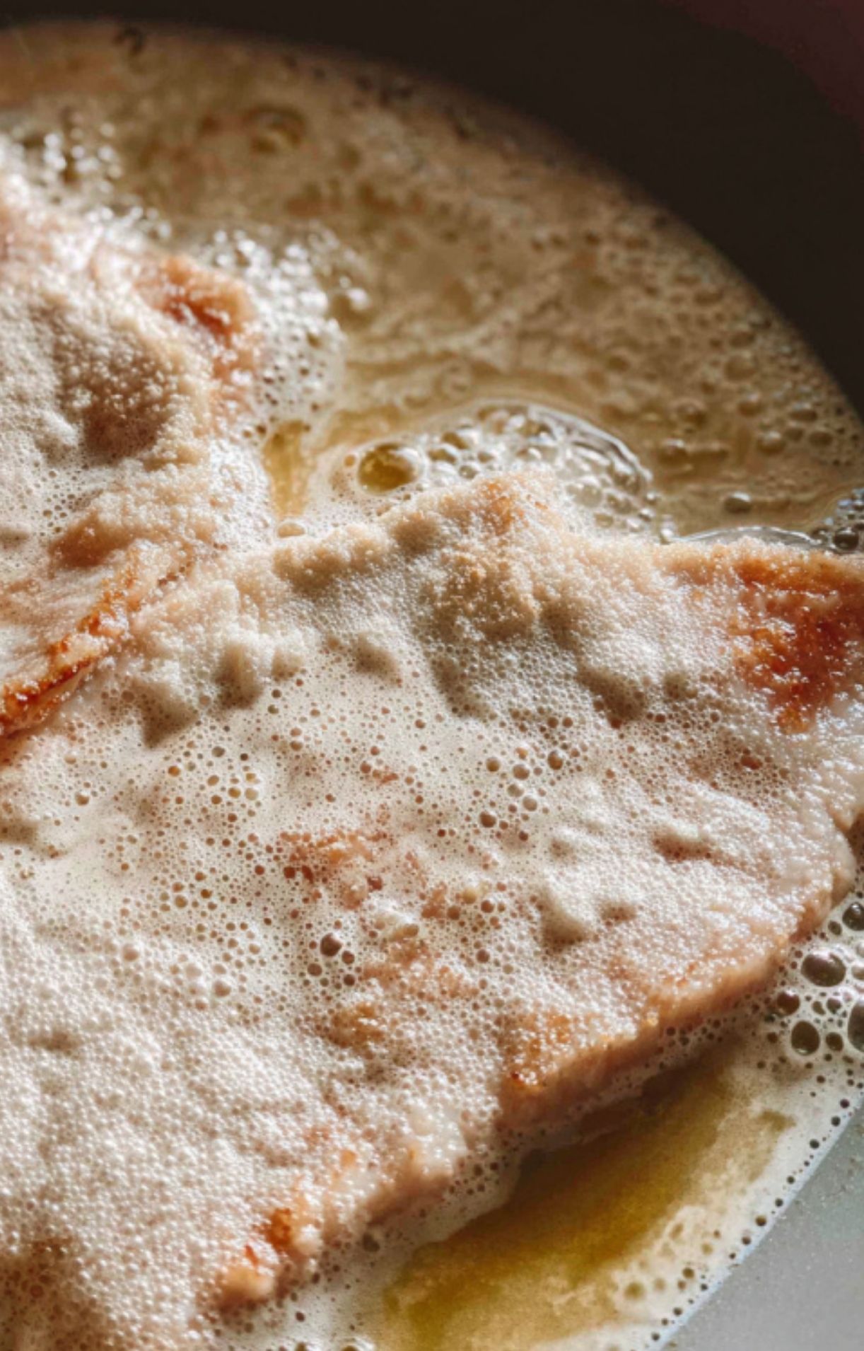Golden brown veal scallopini frying in a bubbly skillet, creating a crispy crust for an easy weeknight Italian meal.