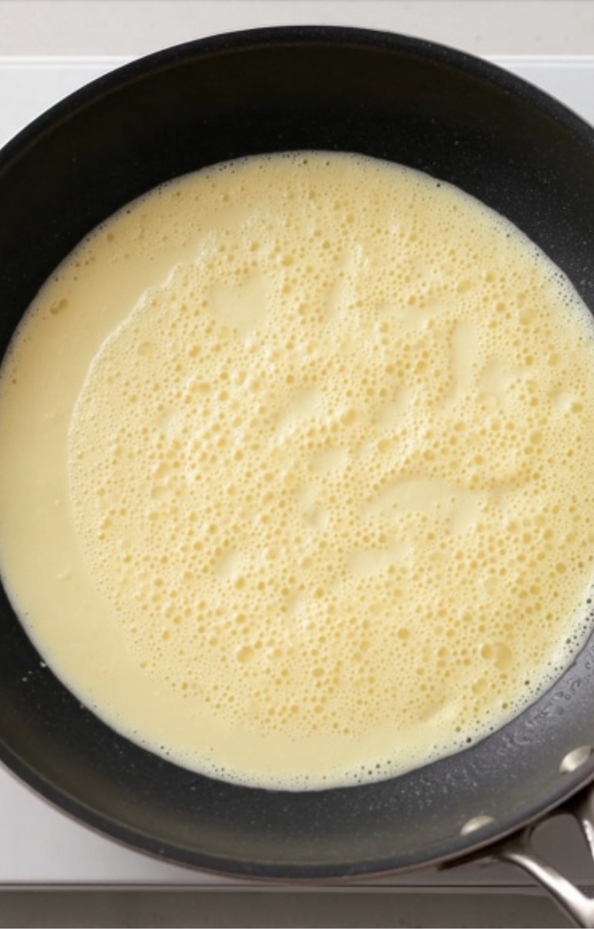 Lemon cream sauce simmering in a nonstick skillet for veal scallopini