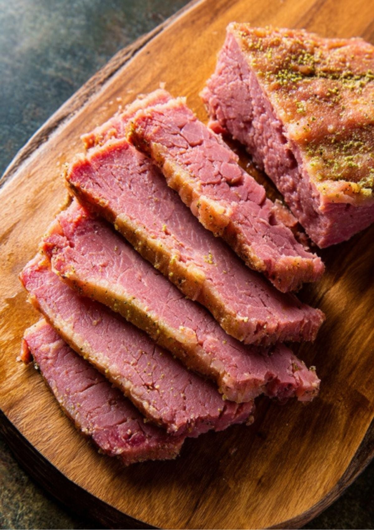 Close-up of sliced pressure cooker corned beef on a wooden board. Juicy, perfectly spiced, and ready for sandwiches or dinner plates.