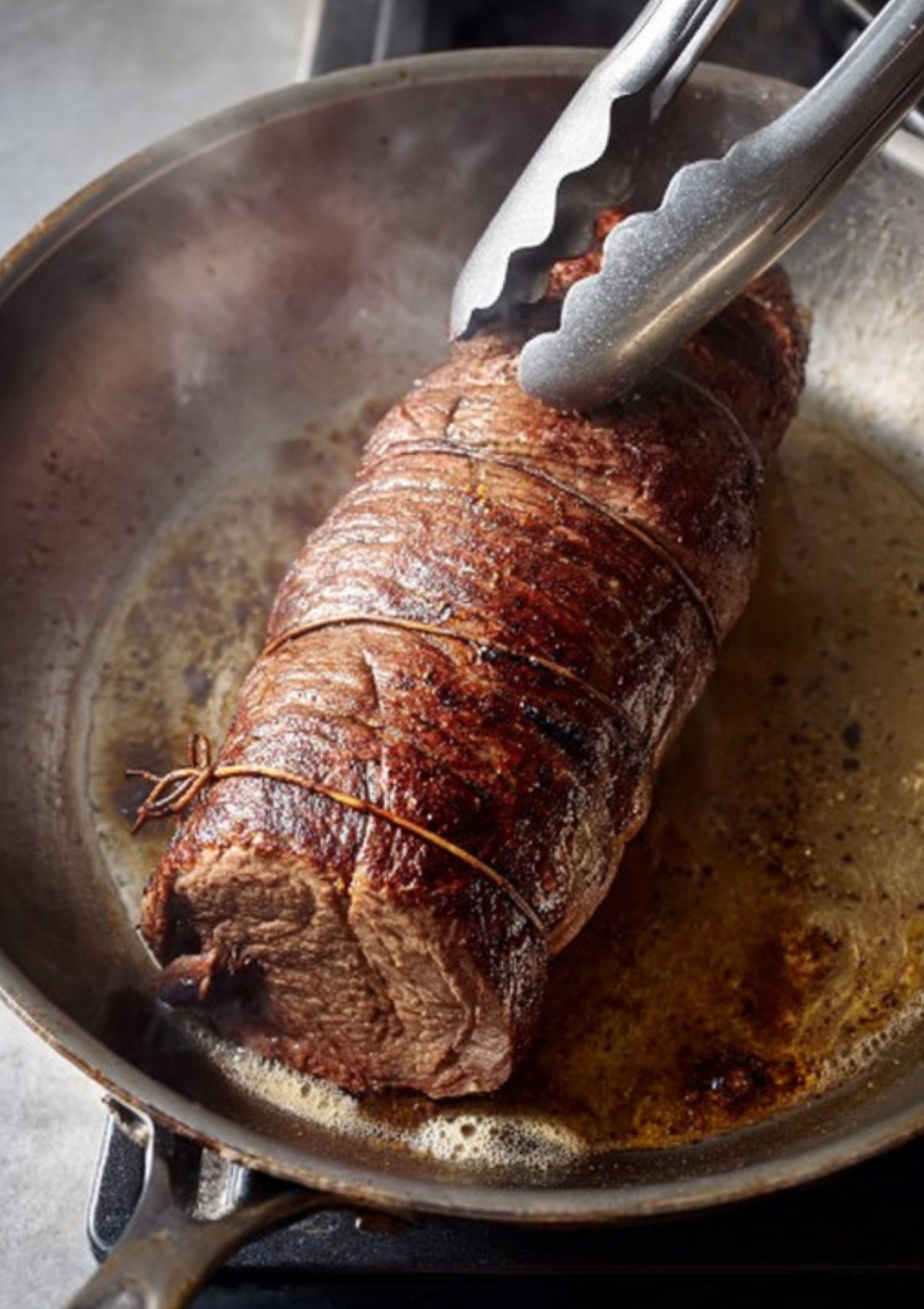 Searing beef tenderloin in a hot skillet for the best beef Wellington puff pastry recipe, perfect for Christmas dinner, holiday parties, and elegant celebrations.