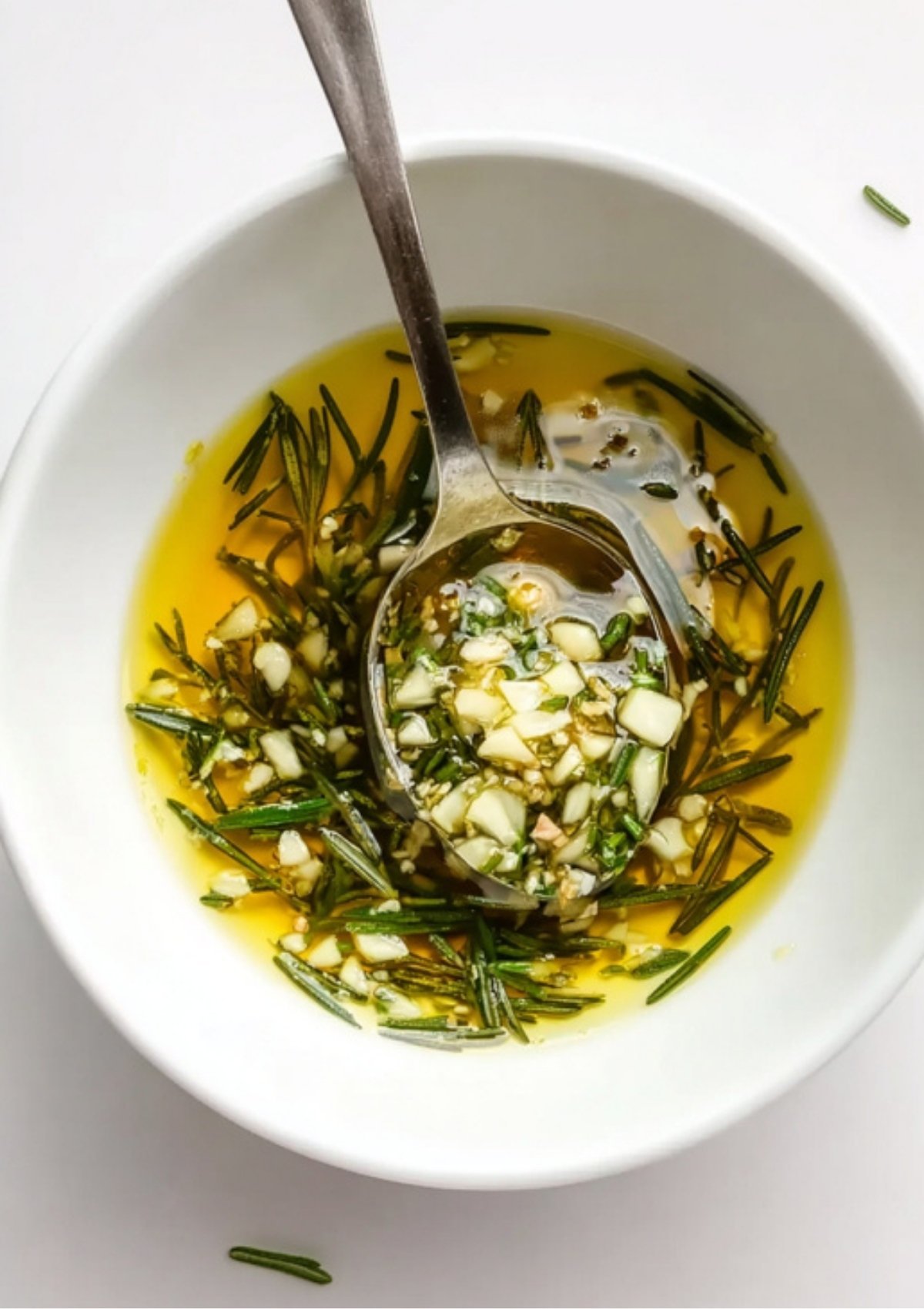Bowl of olive oil mixed with chopped garlic and fresh rosemary for lamb seasoning
