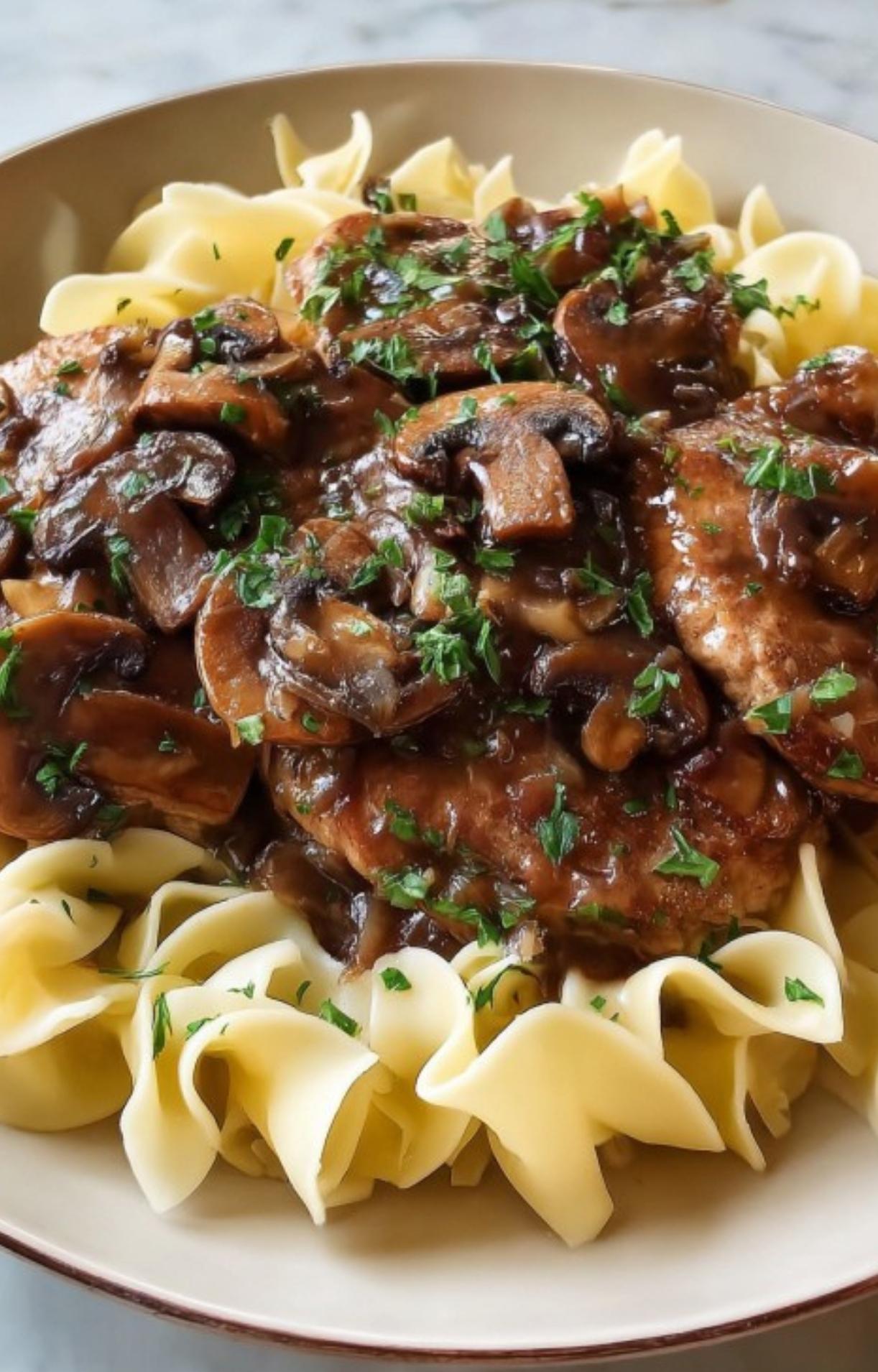 Veal scallopini topped with rich mushroom Marsala sauce, served over wide egg noodles and garnished with parsley