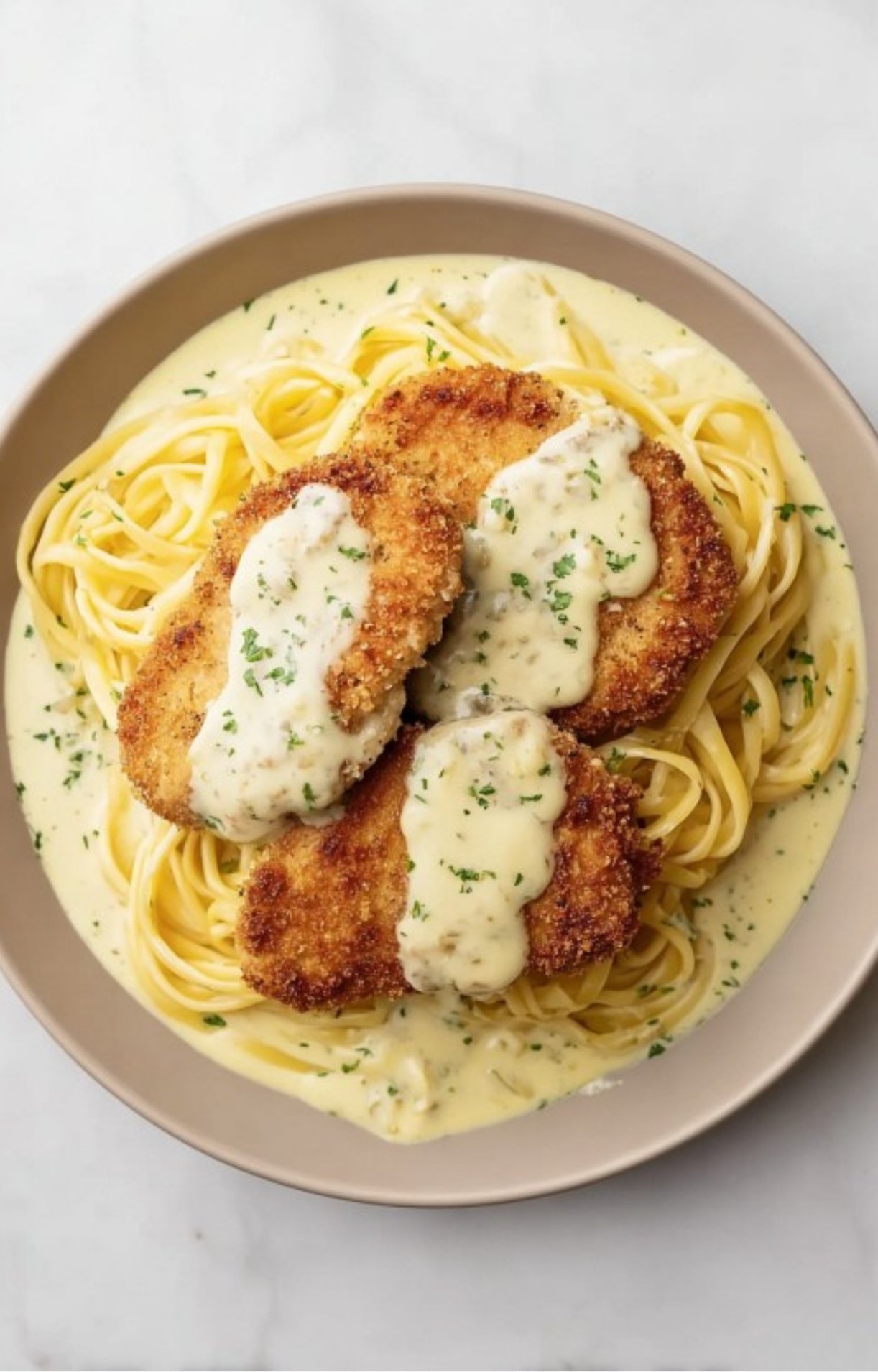 Breaded veal scallopini served over linguine and covered in lemon cream sauce