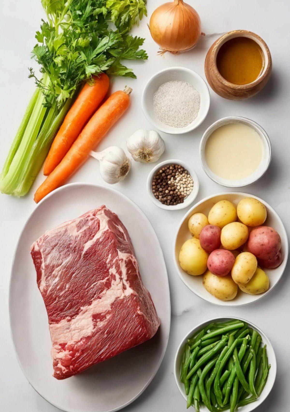 Overhead view of corned beef brisket, potatoes, carrots, celery, onion, green beans, garlic, spices, broth, and cream ready for cooking.