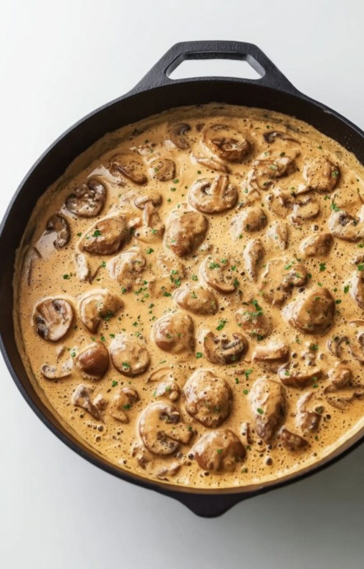 Rich homemade mushroom cream sauce simmering in a skillet. Perfect topping for veal scallopini, chicken, or pork. Easy weeknight recipe.