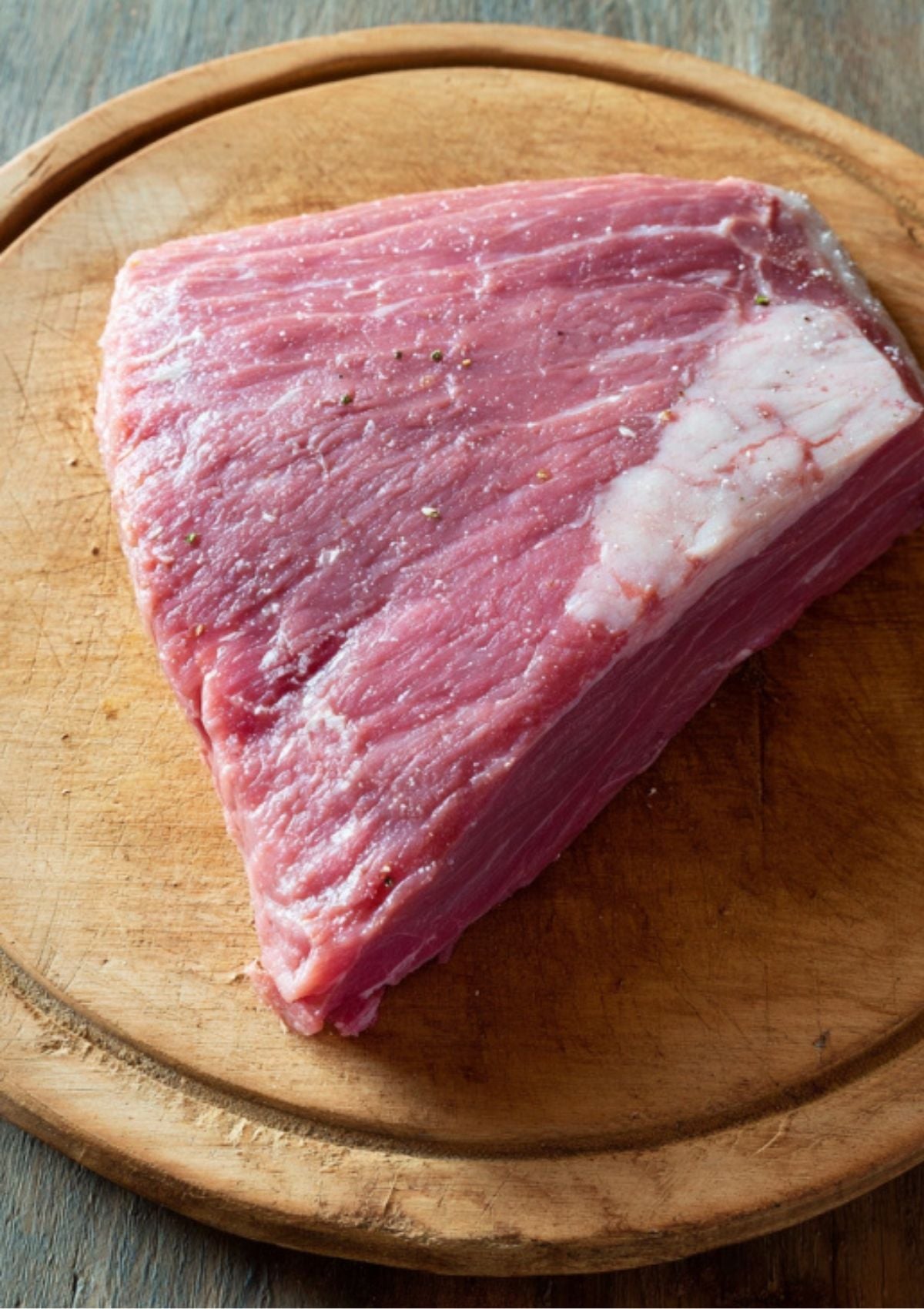 Raw corned beef brisket on a wooden cutting board, ready for seasoning and pressure cooking. The first step to juicy, tender corned beef at home.
