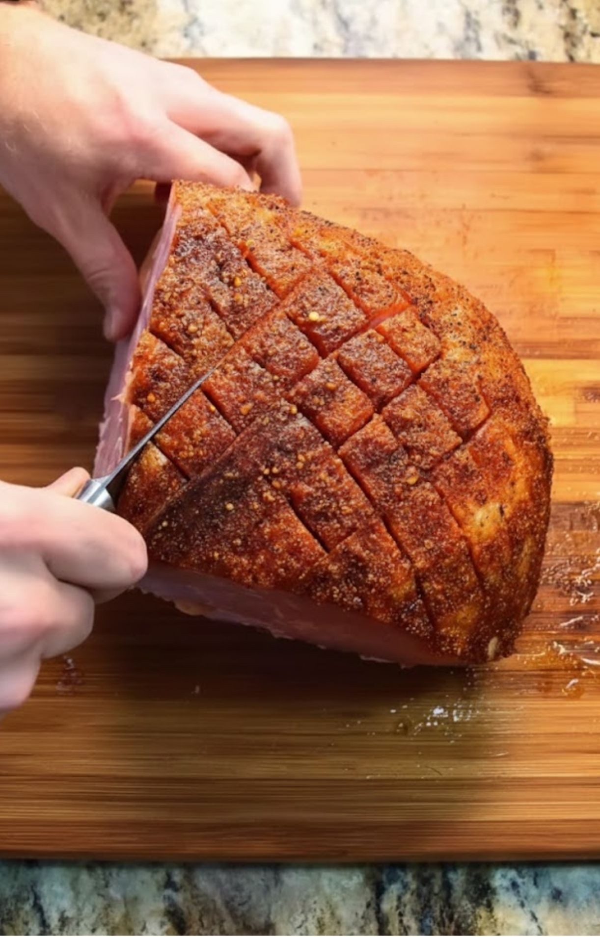 Slicing smoked precooked ham on wooden cutting board