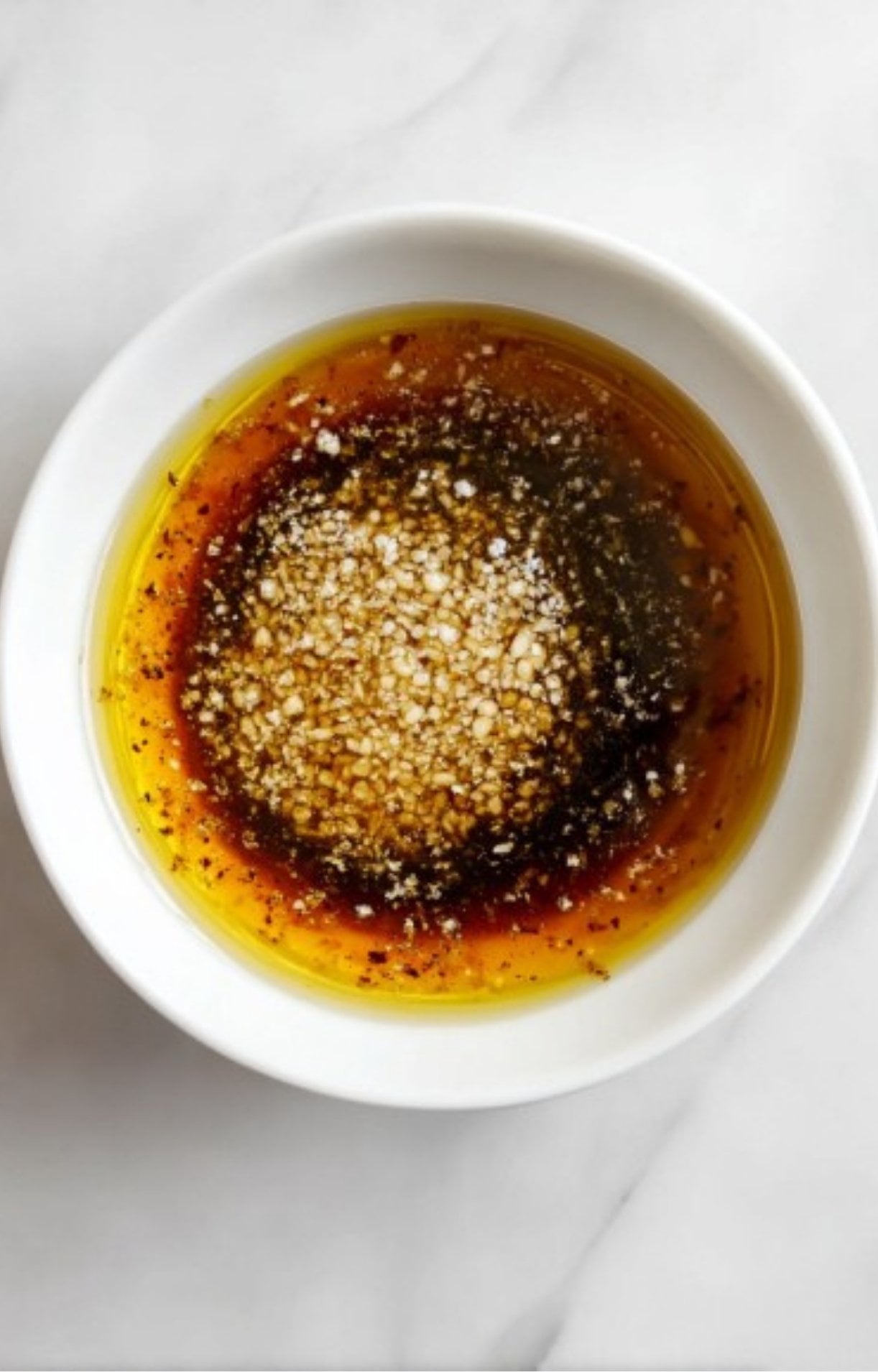 Bowl of steak marinade with oil, garlic, and spices ready for soaking the bavette steak.
