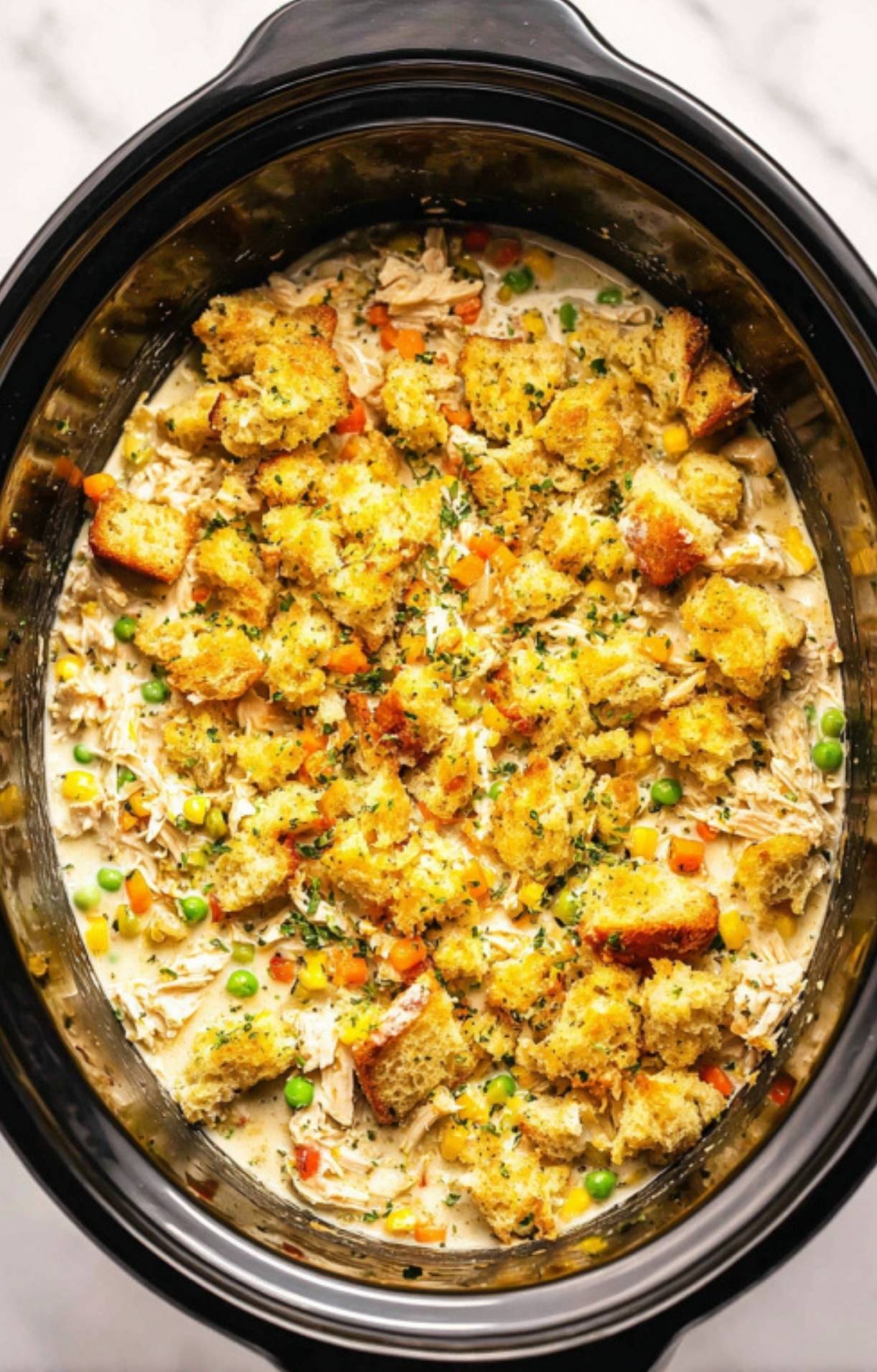 Fresh cubes of herb-seasoned stuffing mix spread evenly over the turkey and vegetable filling in the slow cooker before cooking.