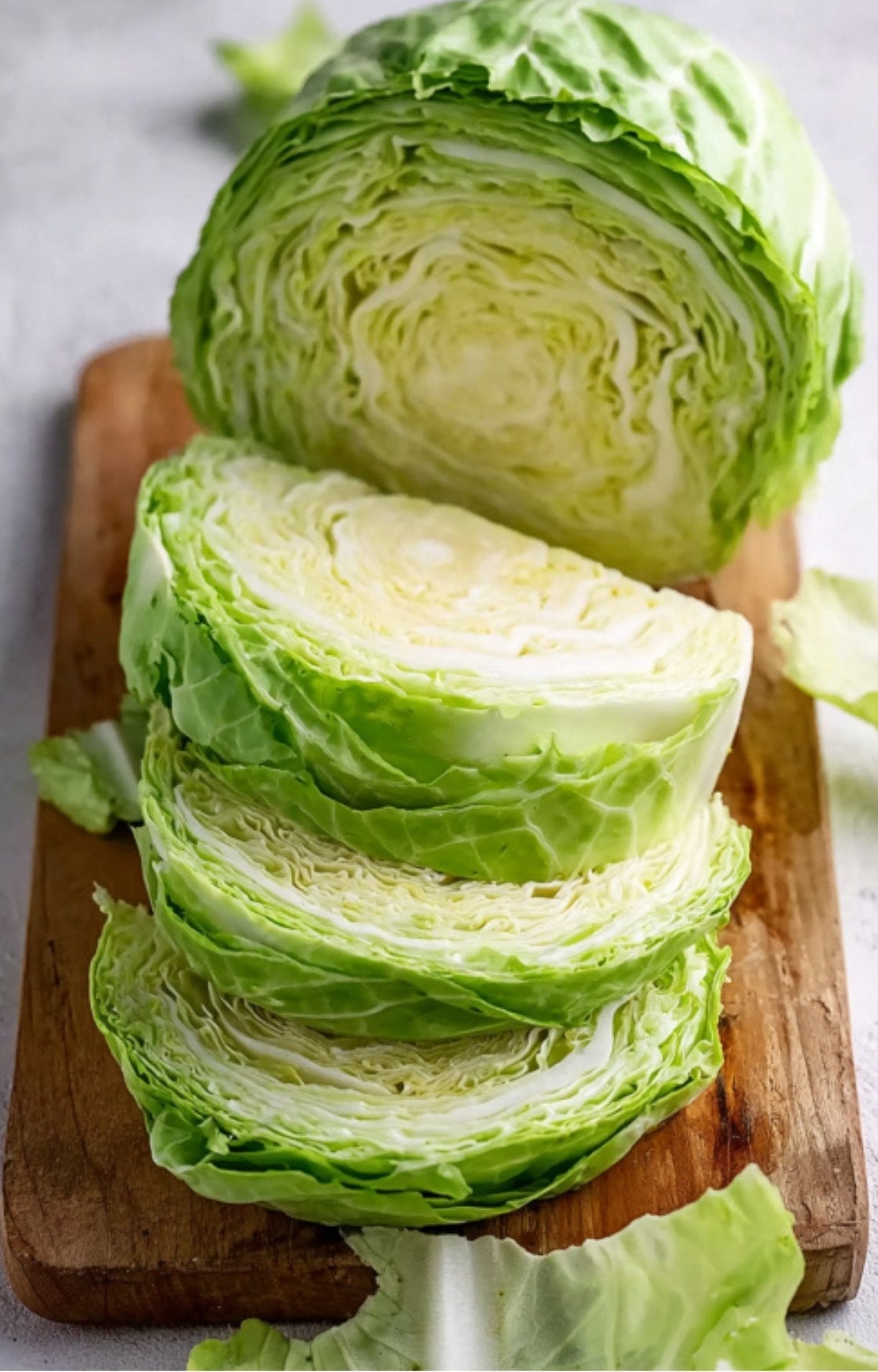 Several thick cabbage slices cut and arranged on a wooden board.