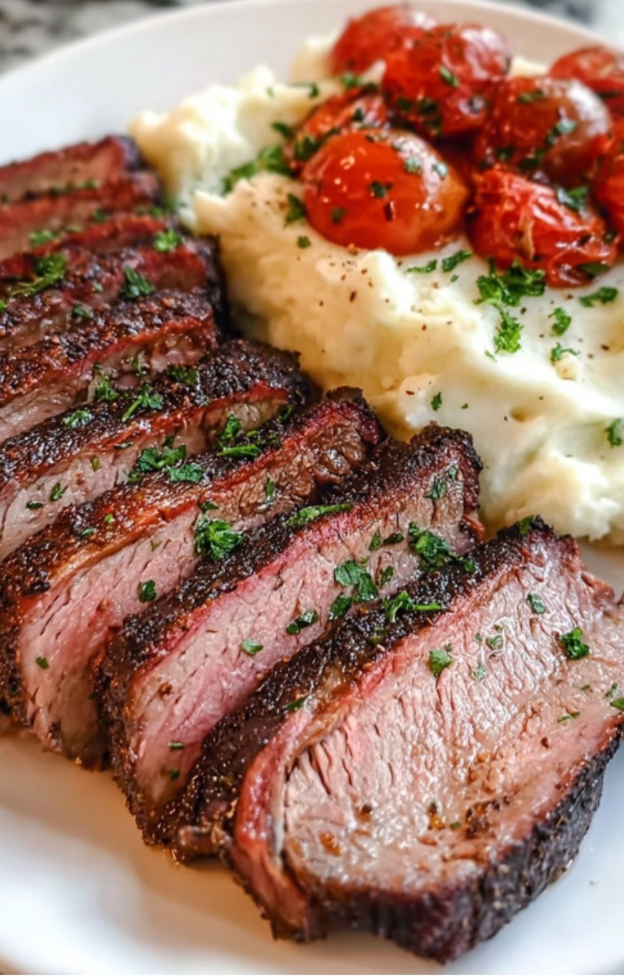 Sliced smoked chuck roast showing a pink smoke ring, garnished with fresh parsley next to potatoes.