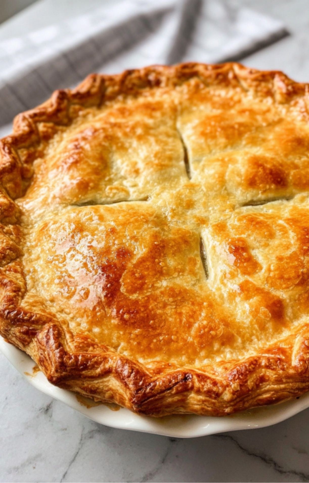 A whole Easy Turkey Pot Pie with a flaky, golden-brown puff pastry crust and decorative vent slits.