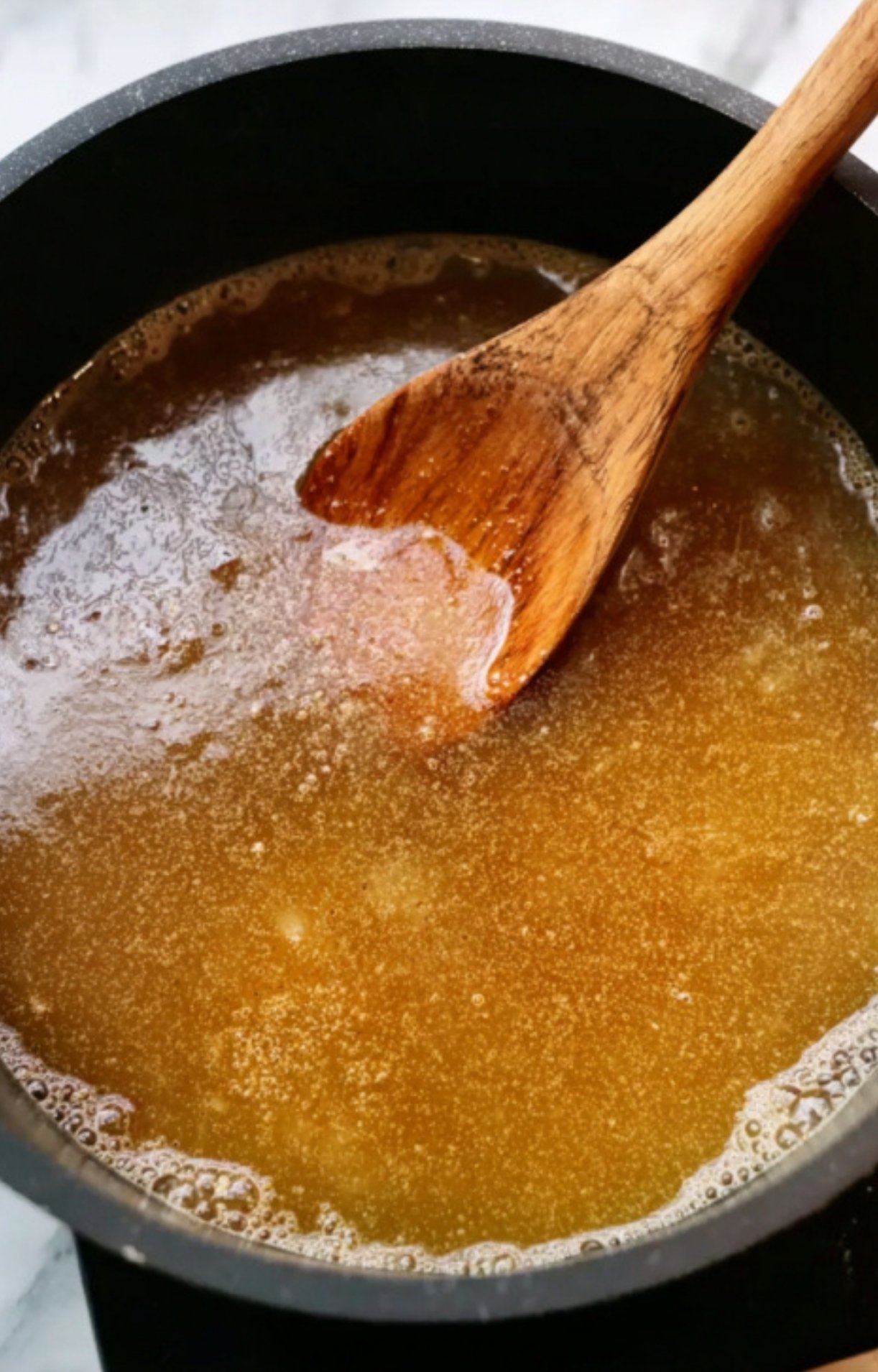 Warm basting sauce for smoked ham in a black pot