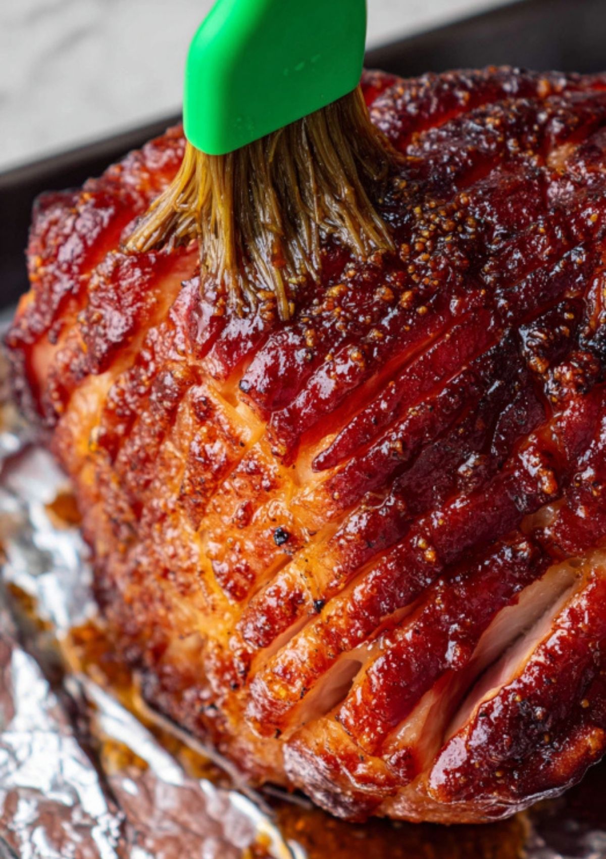 Spiral ham being brushed with sticky brown sugar maple glaze, classic Easter main dish